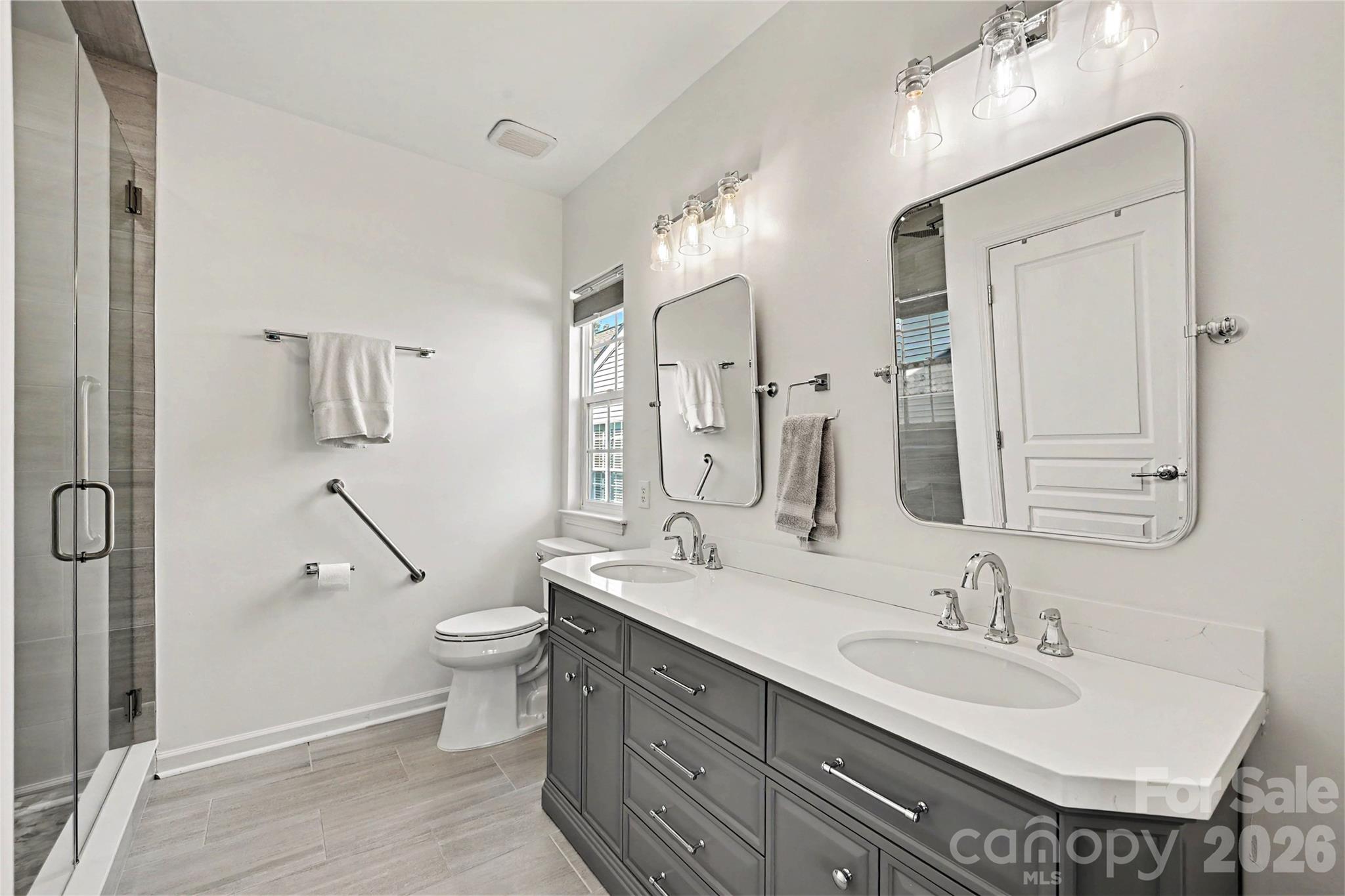 LUXURIOUS Primary Bath with Tile flooring, Quartz countertop, LED fixtures, and frameless tiled shower. - 3054 Azalea Drive, Indian Land