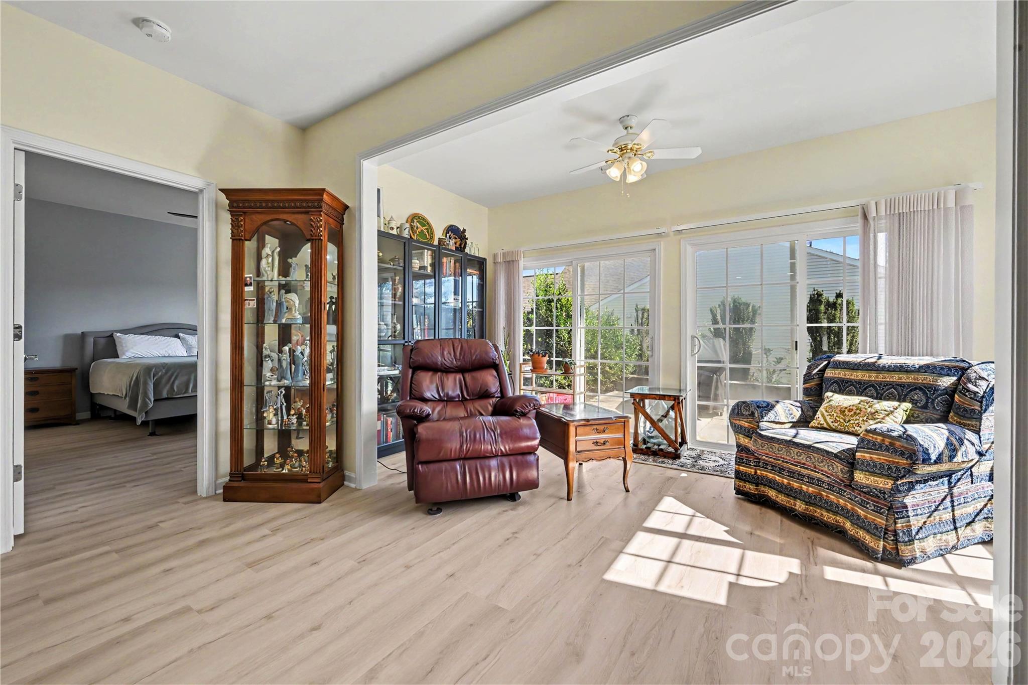 View of Sunroom looking towards the Primary Bedroom showing bright views, NEW LVP flooring and neutral paint. - 3054 Azalea Drive, Indian Land