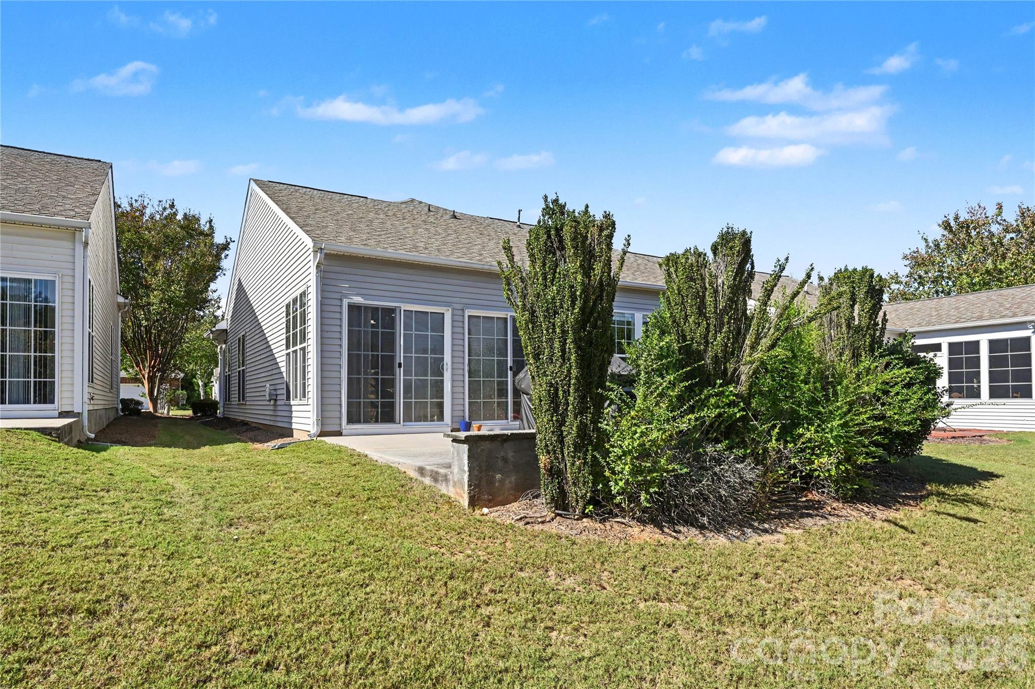 View of Back of Home showing patio, mature landscaping and Knee Wall. - 3054 Azalea Drive, Indian Land
