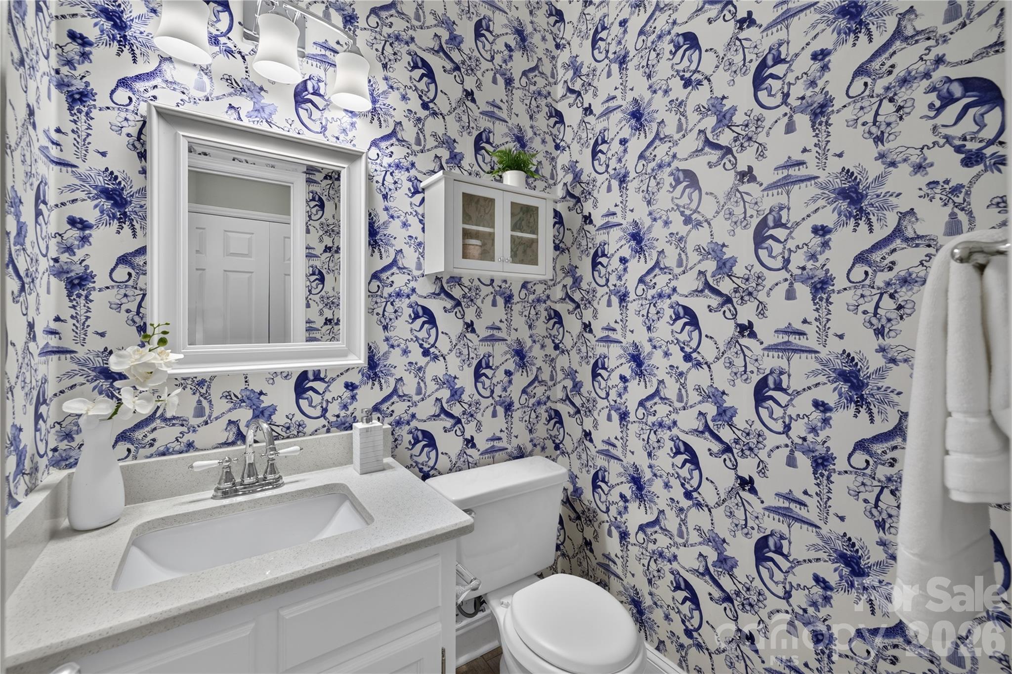 Downstairs half bath with decorative wallpaper. - 4711 Beech Crest Place, Charlotte