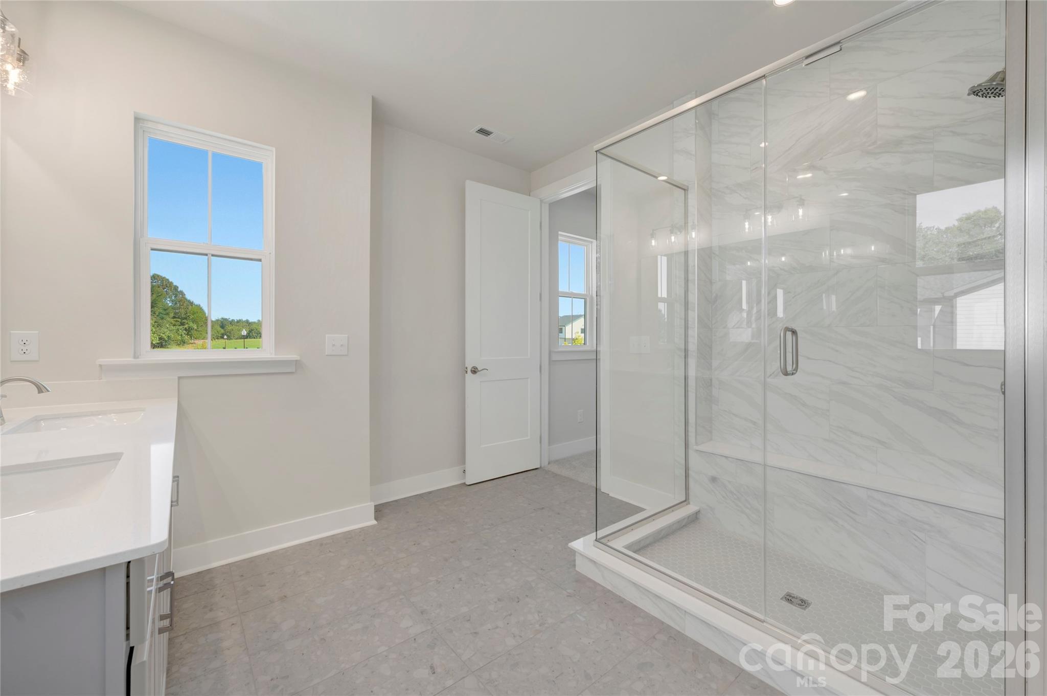 Primary bathroom with tiled walk-in shower featuring a built in seat - 75 Seven Oaks Landing, Belmont