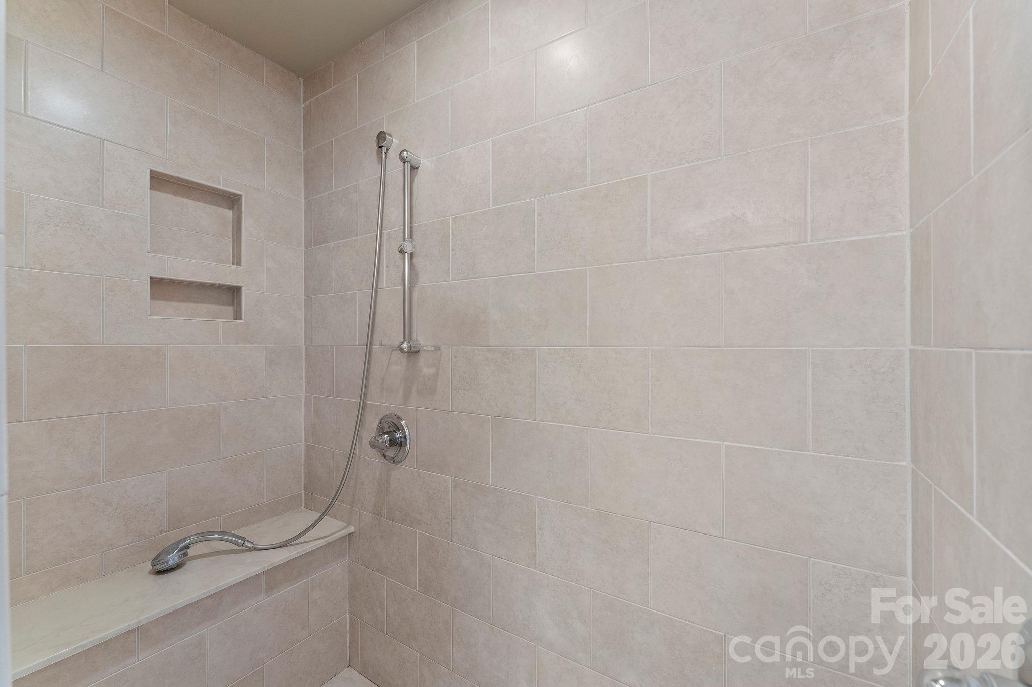 Large tiled shower with bench and niche in the Primary Bathroom - 2006 Grey Road, Davidson
