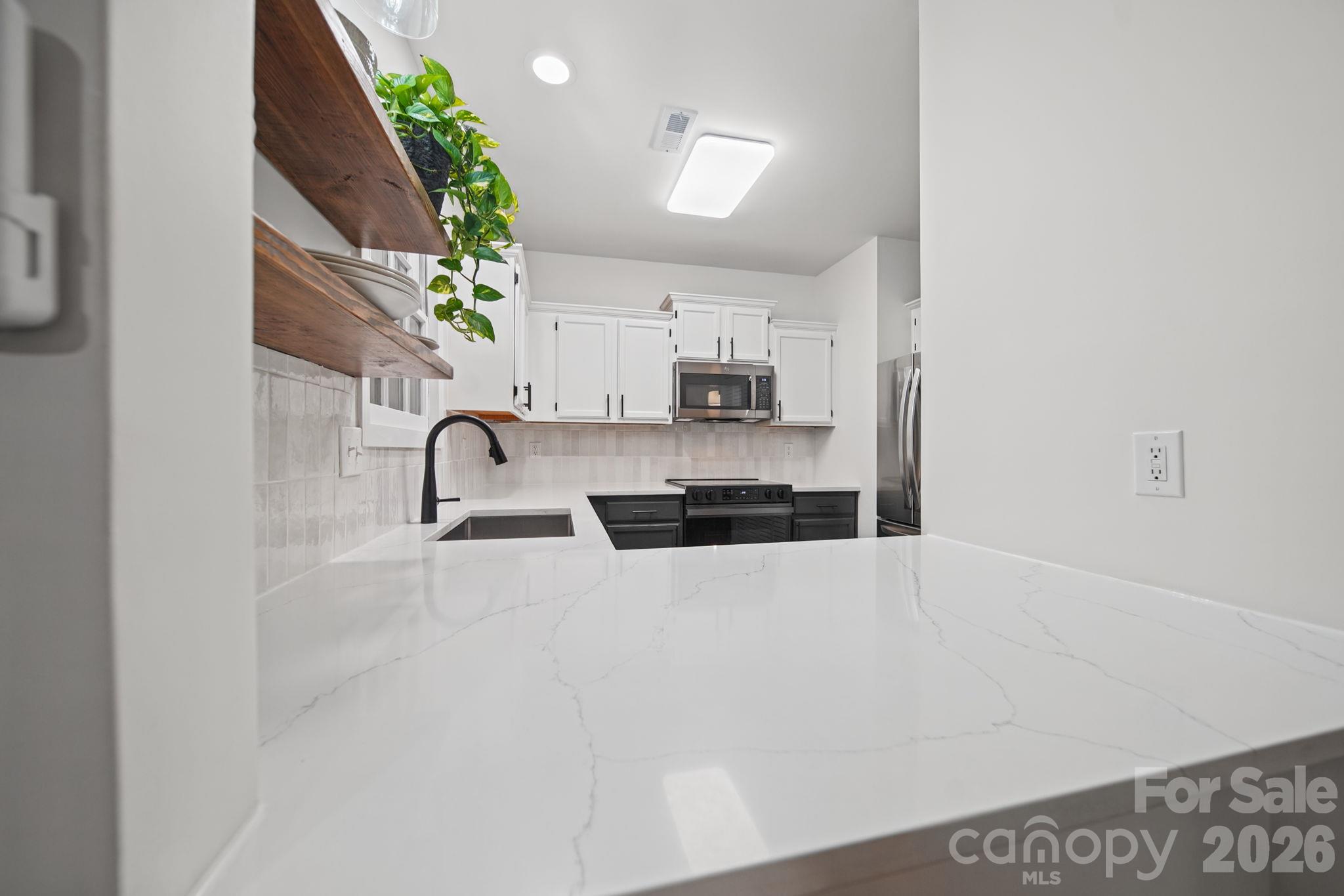 Quartz counter top with lowered countertop bar for additional seating - 3302 Selwyn Farms Lane, Charlotte