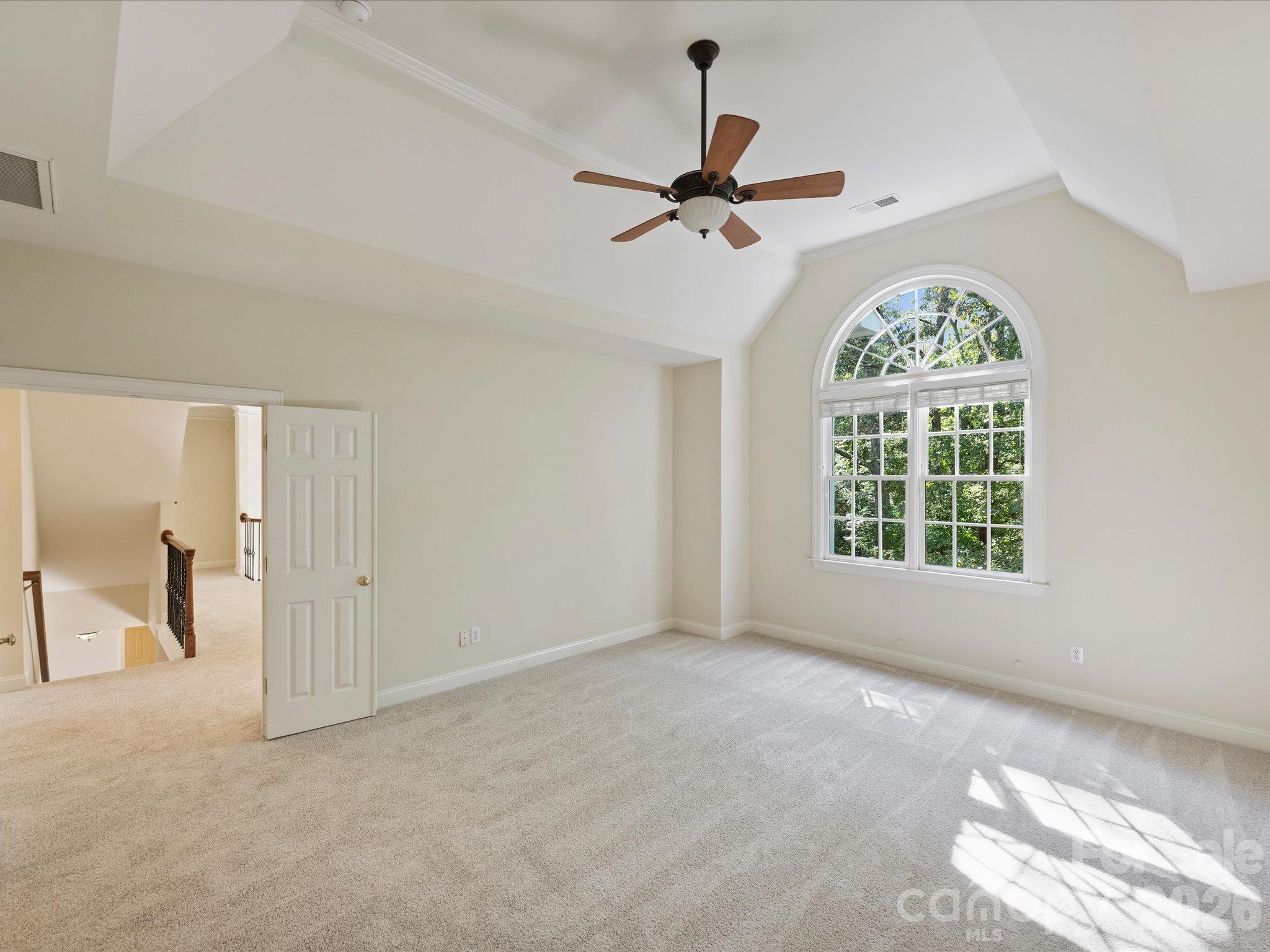 Primary bedroom with tray ceiling and picture window - 7705 Stonehaven Drive, Waxhaw
