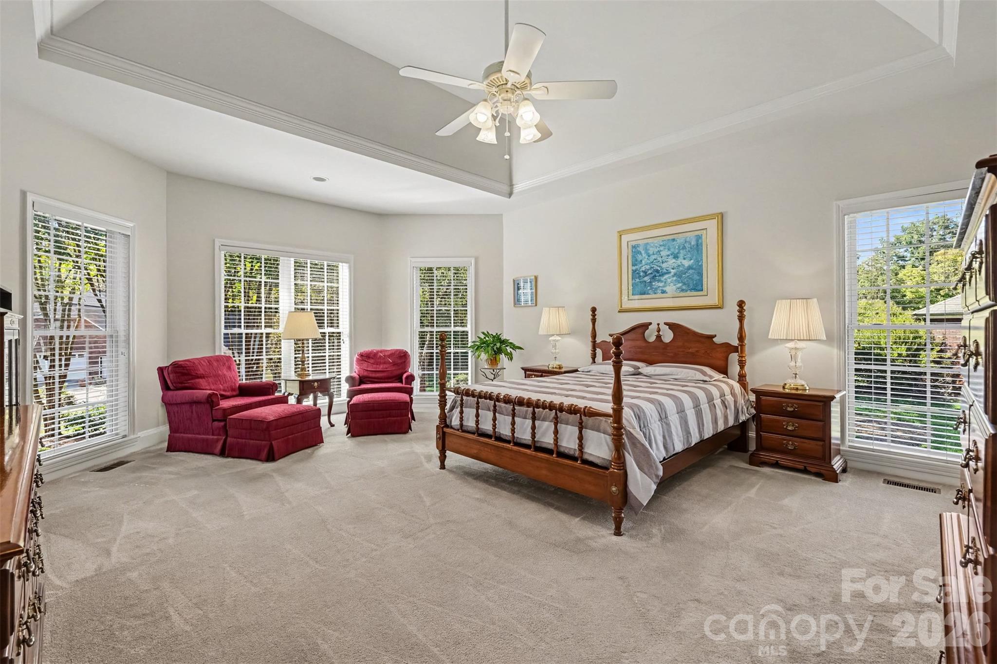 This luxurious Primary Bedroom is located on the main level. Relax and unwind in this spacious bedroom with sitting area and bay window. Lots of Natural Lighting. Neutral Carpeting and Paint. Deep Trey Ceiling. - 8412 Locksley Drive, Harrisburg