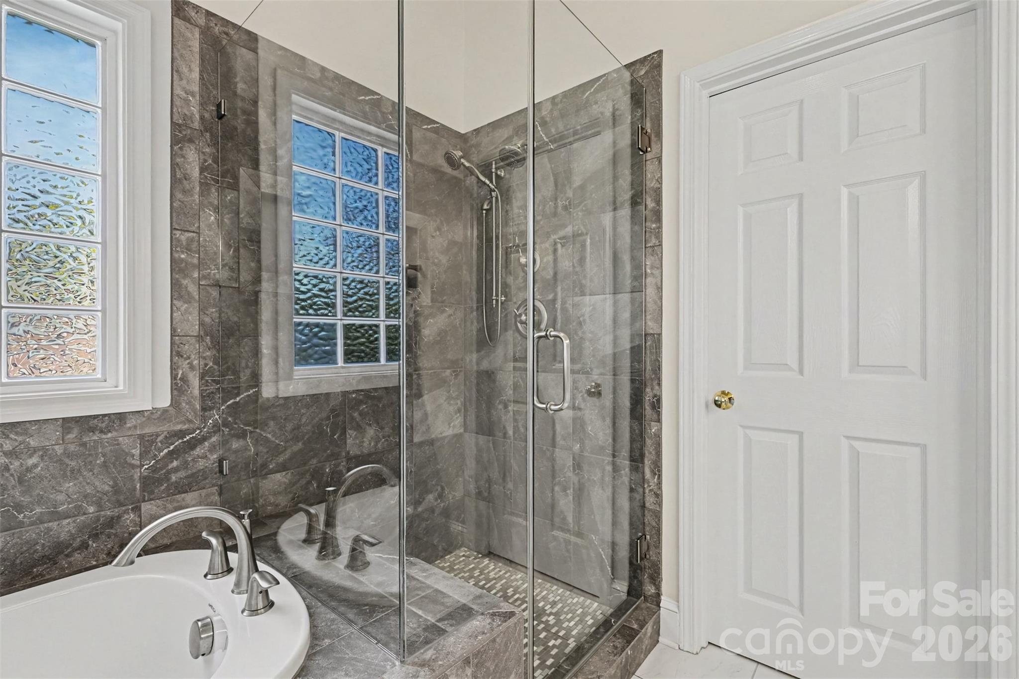 Beautifully updated Shower and Tub. Seamless Glass Enclosure around beautiful Gray Tile and Privacy Window. - 8412 Locksley Drive, Harrisburg