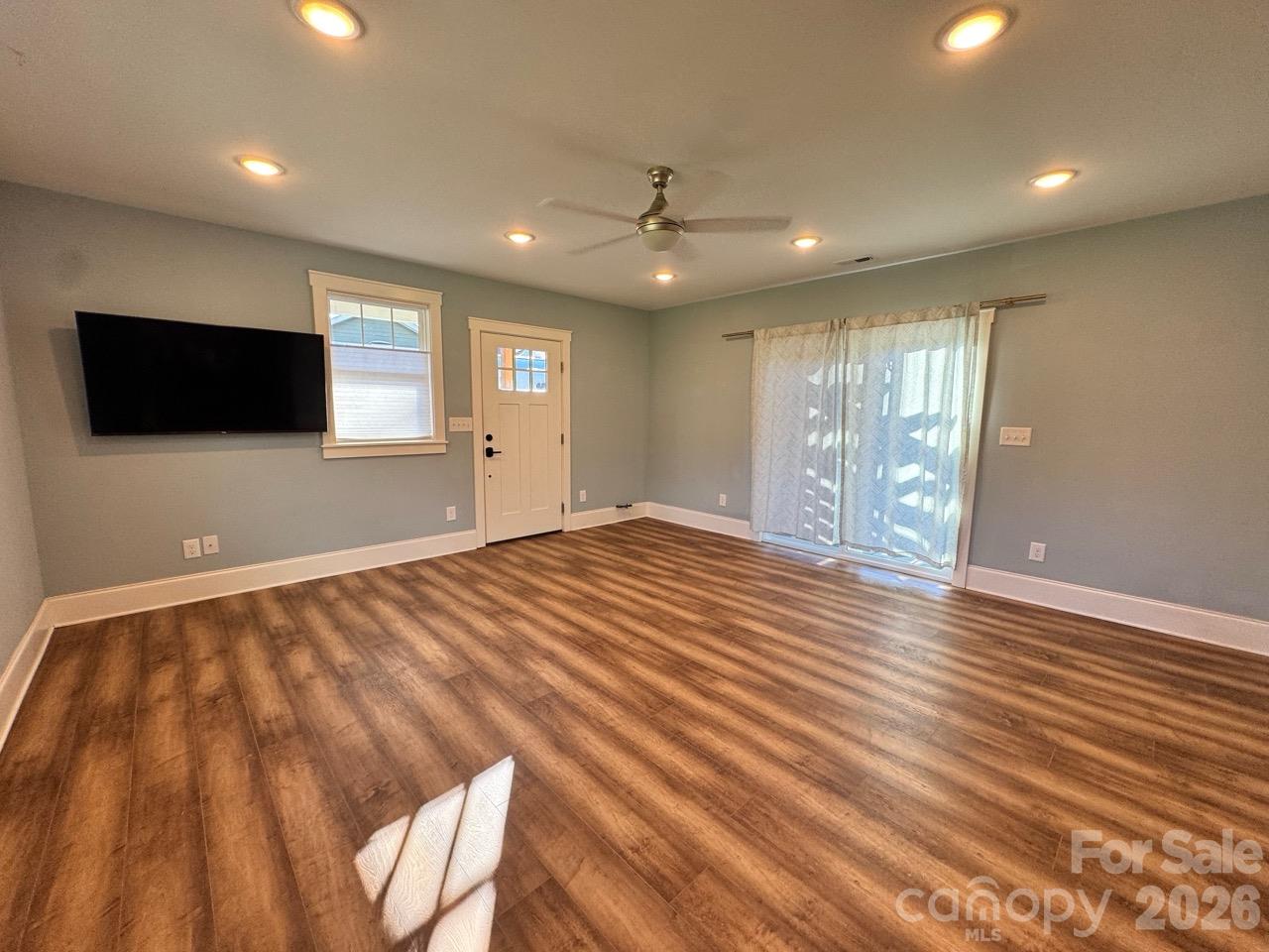 Front entry to living room.  Gorgeous LVP flooring throughout except tile in bathroom. Sliding door is to small patio. TV stays!! - 52 North Lane, Brevard