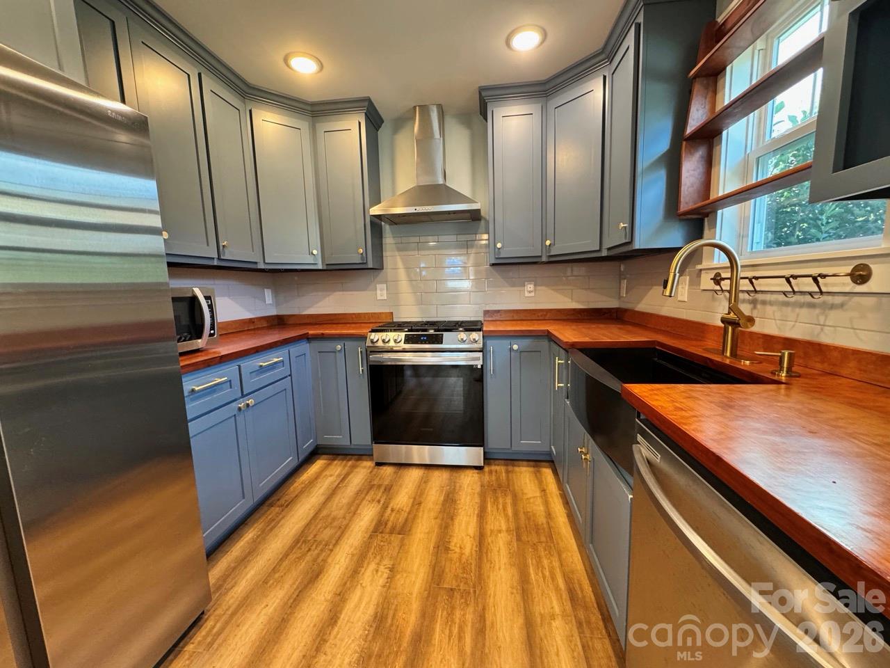 Sleek kitchen with SS appliances, cherry wood countertops, tile backsplash and farm sink.  Notice the propane gas range!!! - 52 North Lane, Brevard
