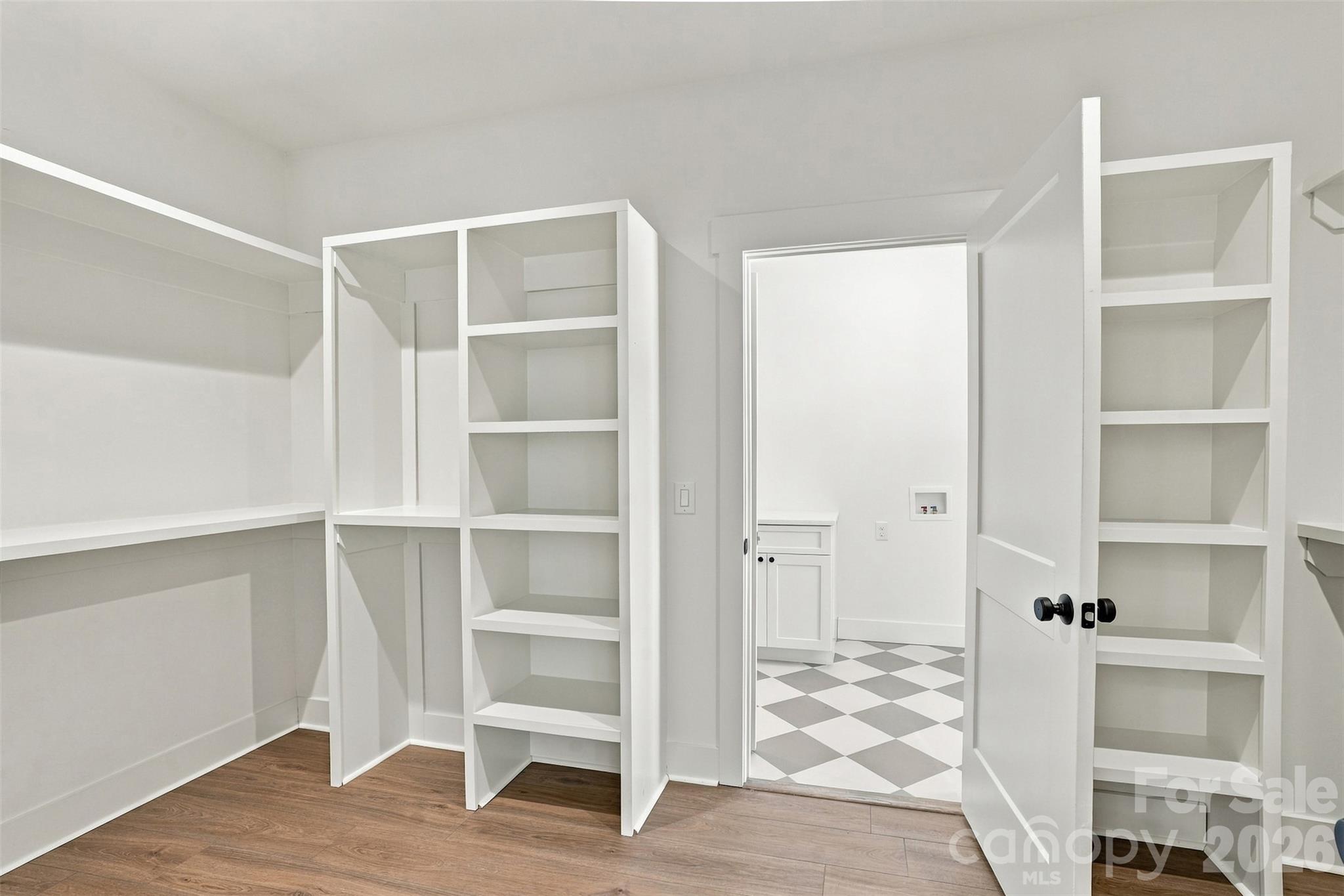 Primary Closet with Custom Shelving leading into laundry room - 219 Barra Drive, Waxhaw