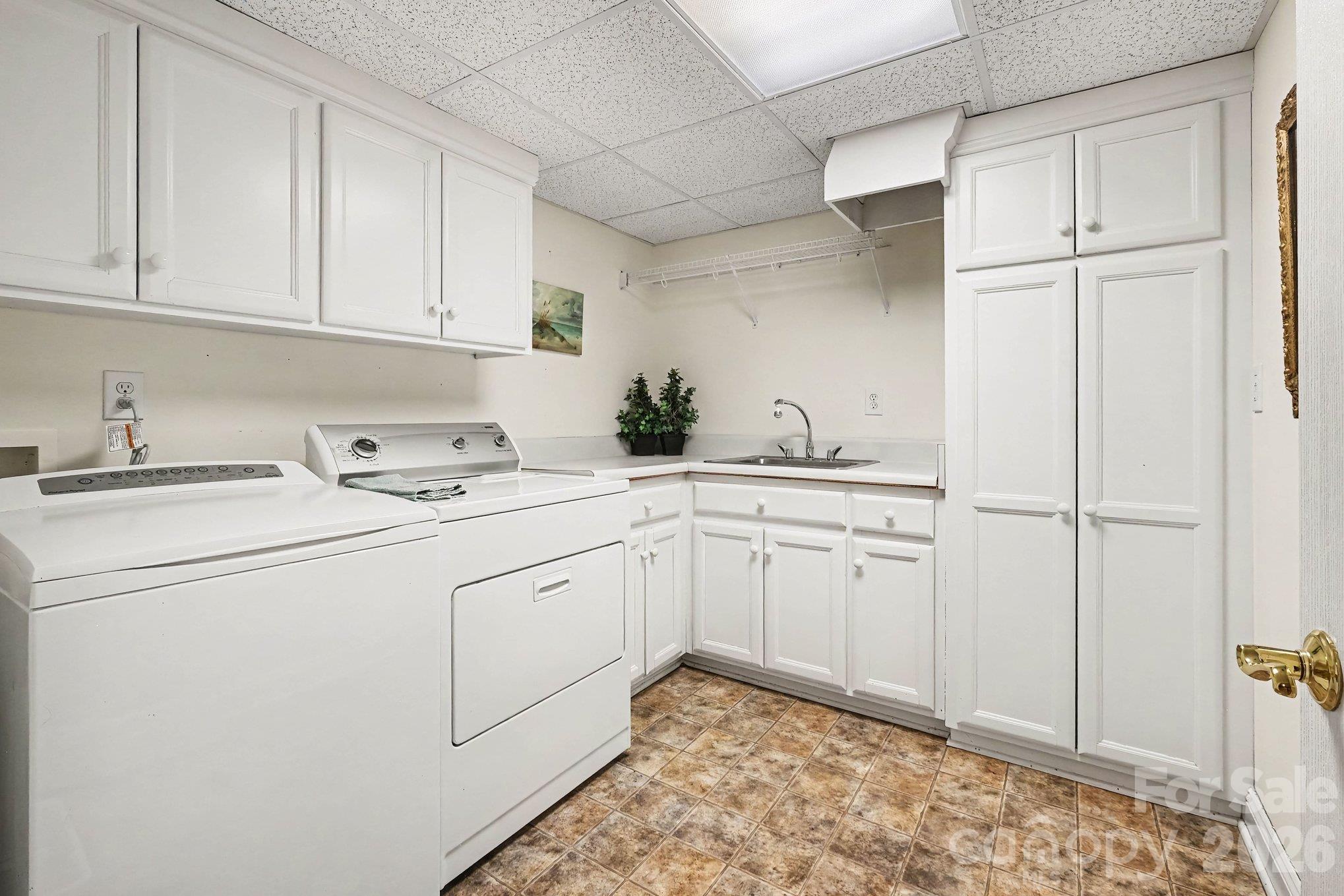 Spacious laundry room with sink, chute, and additional storage cabinets - 746 Grandview Drive NE, Concord