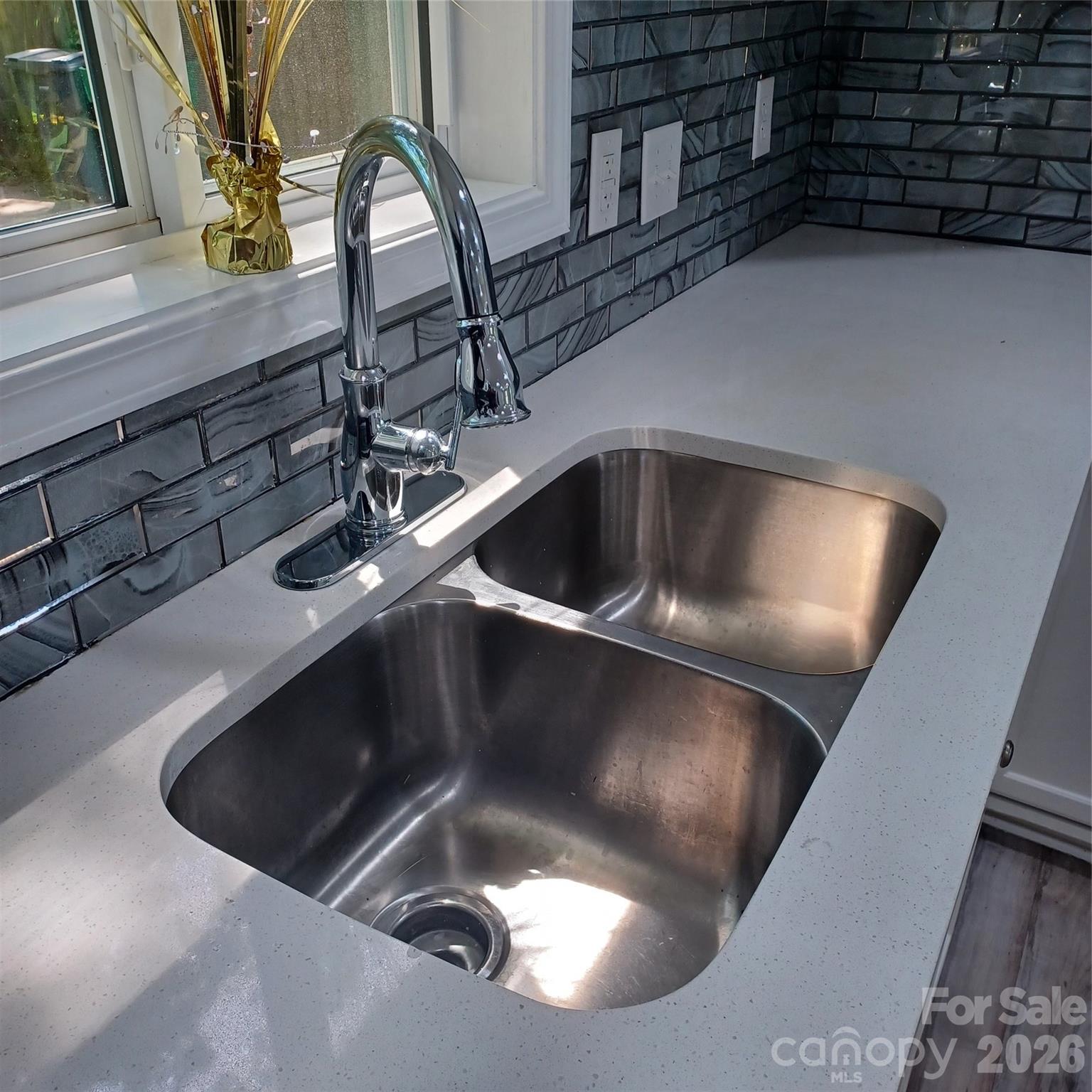 Beautifully updated kitche sink, faucet, and countertops with Glass backspash - 5717 Ruth Drive, Charlotte