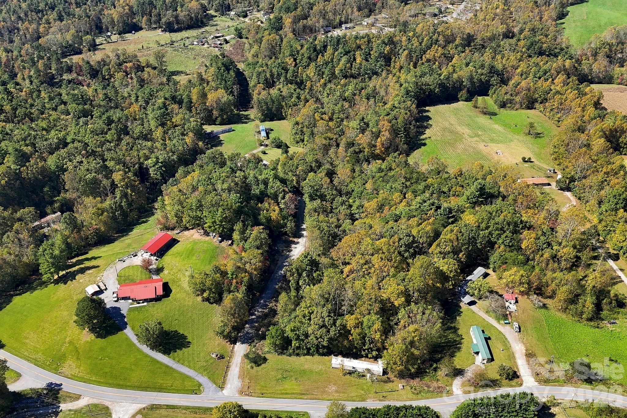 Aerial view showcasing convenient paved road frontage, established access points, and a beautiful mixture of open and wooded acreage. - 631 Union Hill Road, Hendersonville