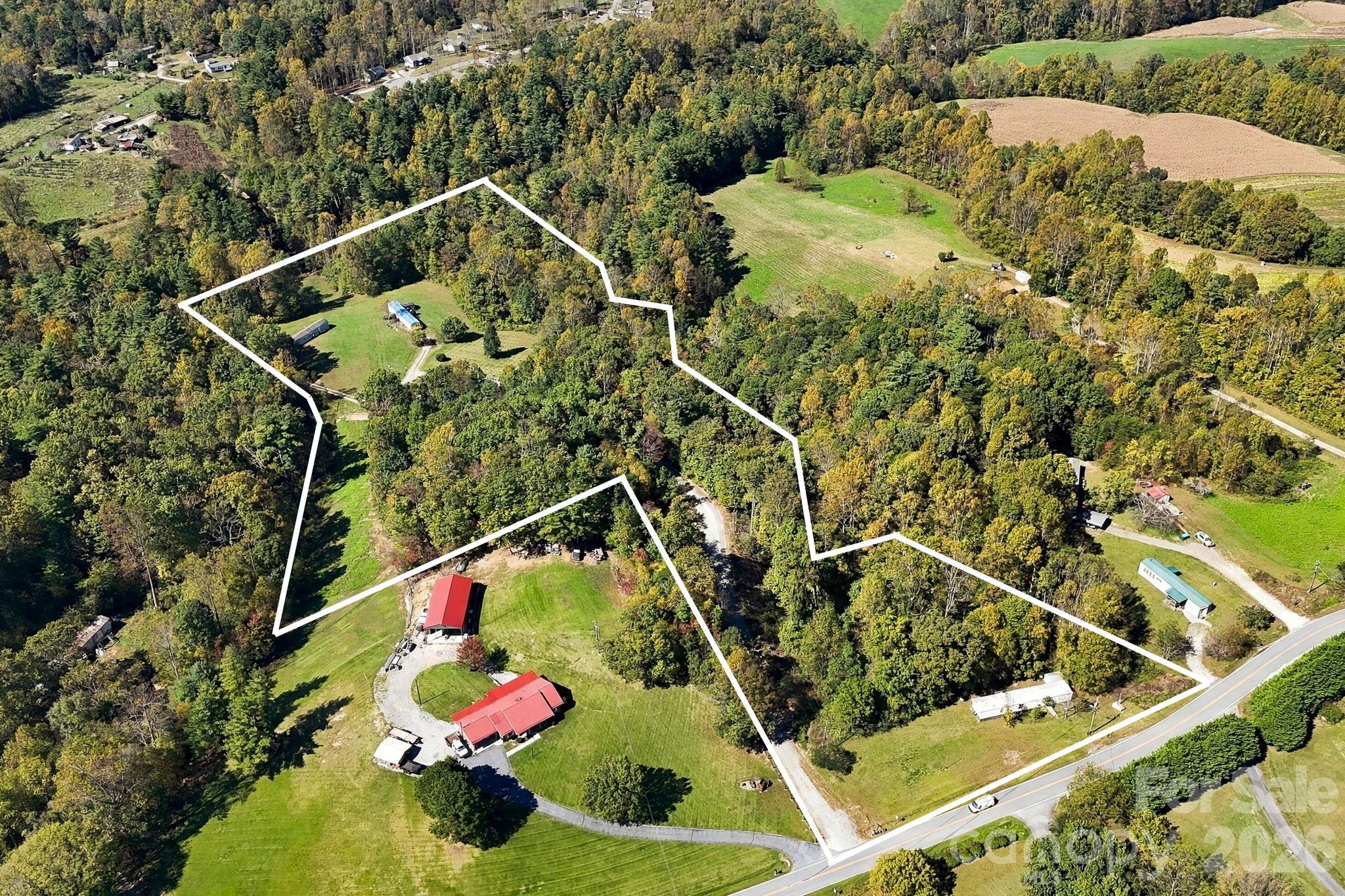 Approximate property boundaries illustrate the unique configuration of this 10.74-acre tract, including state-road frontage, wooded acreage, and existing residential sites. - 631 Union Hill Road, Hendersonville