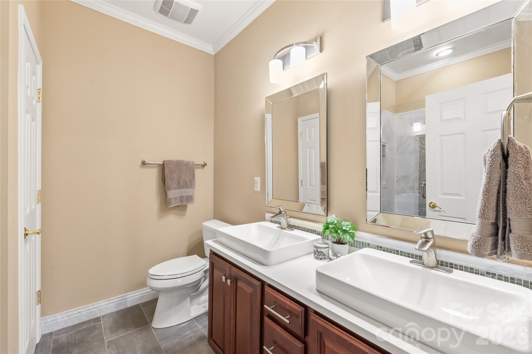 Outfitted with crisp tile flooring, an updated vanity with ample storage, and rich quartz surfaces, this refreshed primary bath blends style with everyday functionality. - 4780 Grier Farm Lane, Charlotte