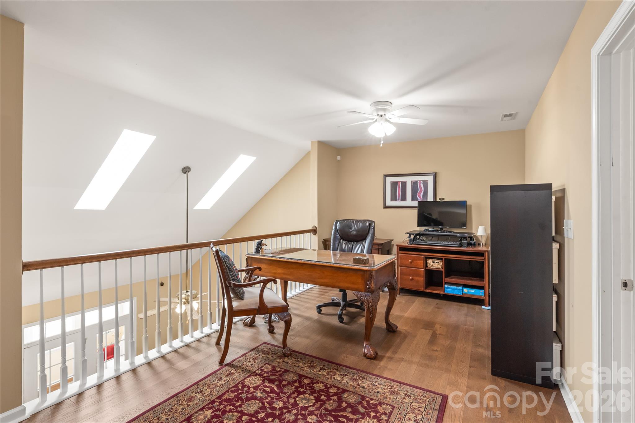 Bright, open, and connected! The upper loft overlooks the soaring living room below, bathed in incredible natural light from the updated skylights above. - 4780 Grier Farm Lane, Charlotte