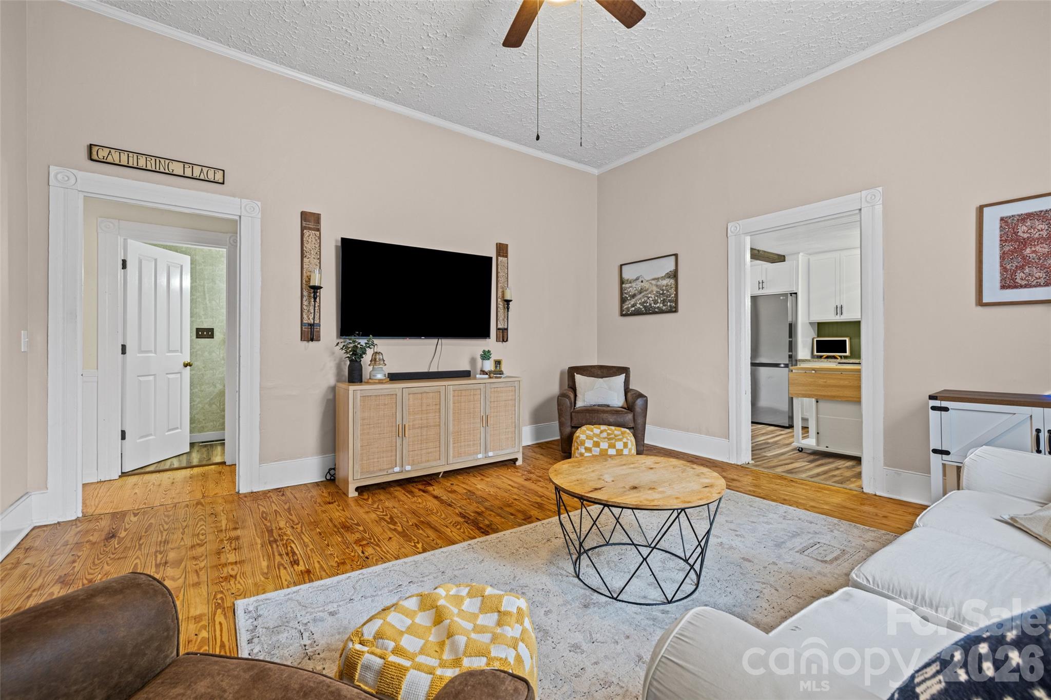 Another view of the spacious living room showcasing original hardwood floors, tall ceilings, and an easy flow into the adjoining rooms. - 231 E Jefferson Street, York