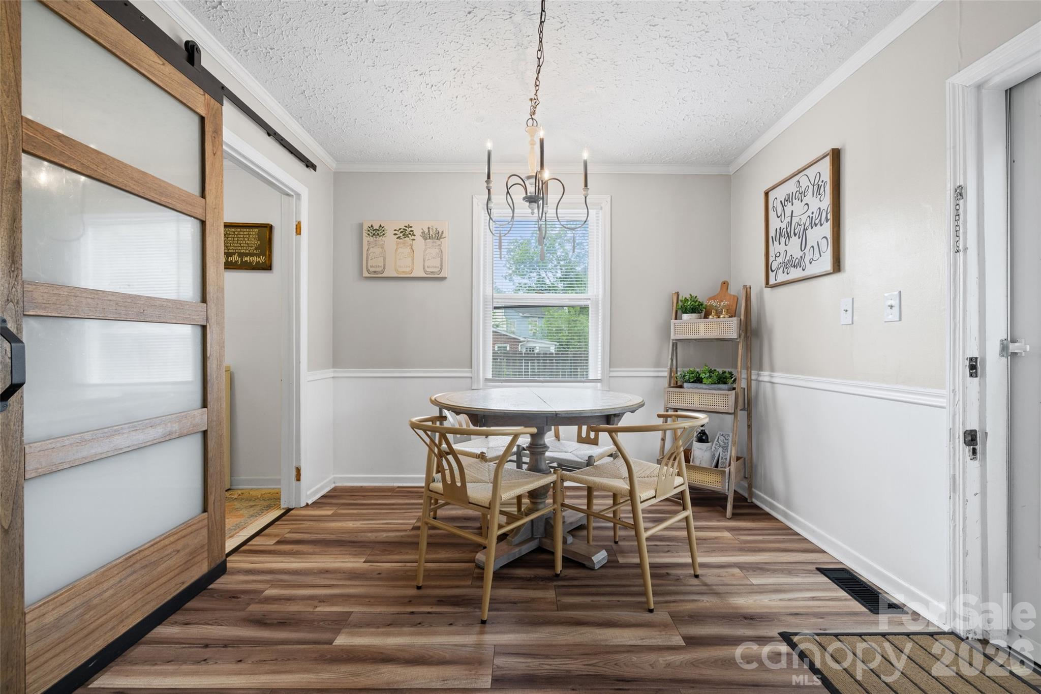 Another view of the dining space featuring updated flooring, classic wainscoting, and plenty of natural light. - 231 E Jefferson Street, York