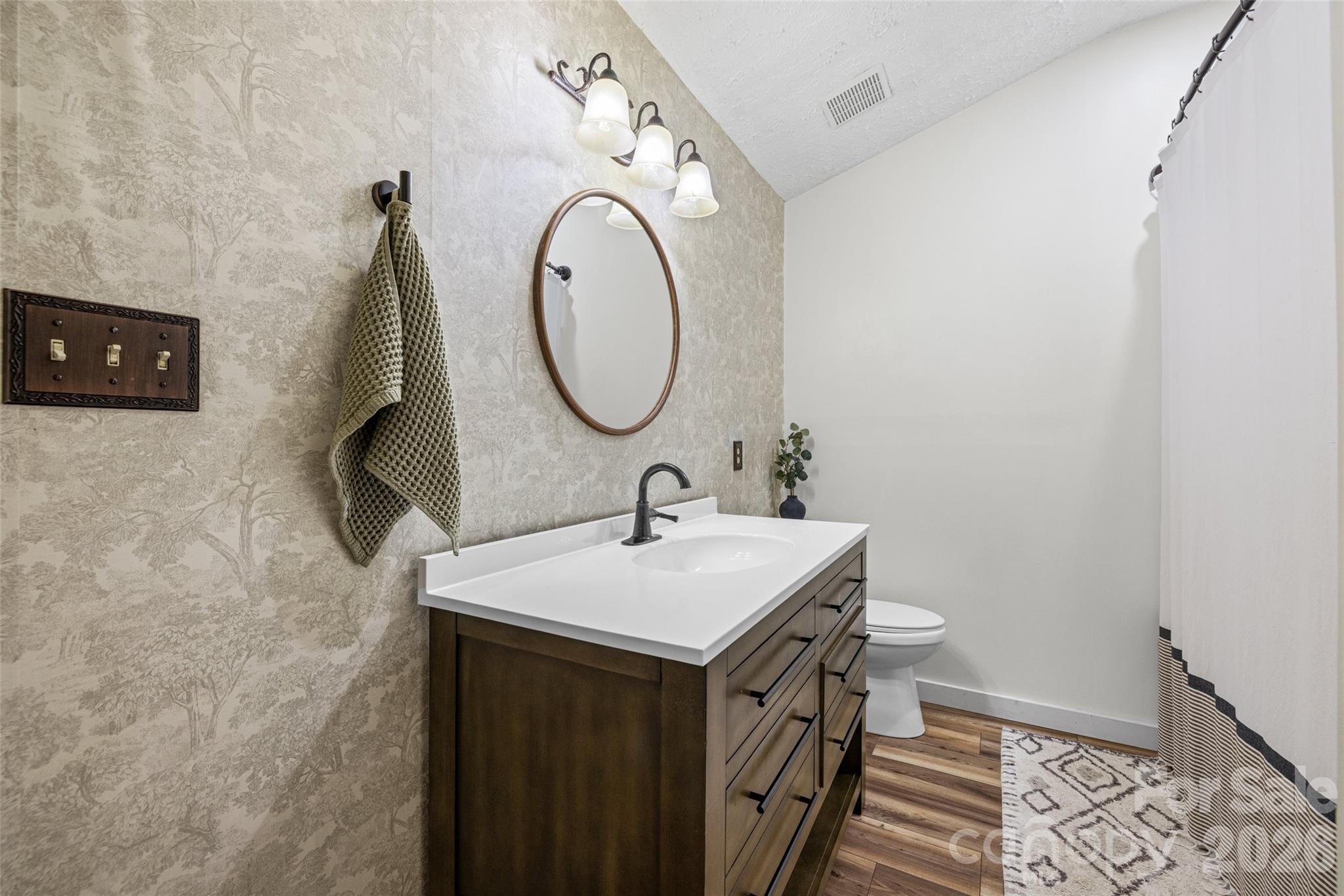 Beautifully updated bathroom featuring a new vanity, modern fixtures, stylish mirror, and updated lighting. - 231 E Jefferson Street, York