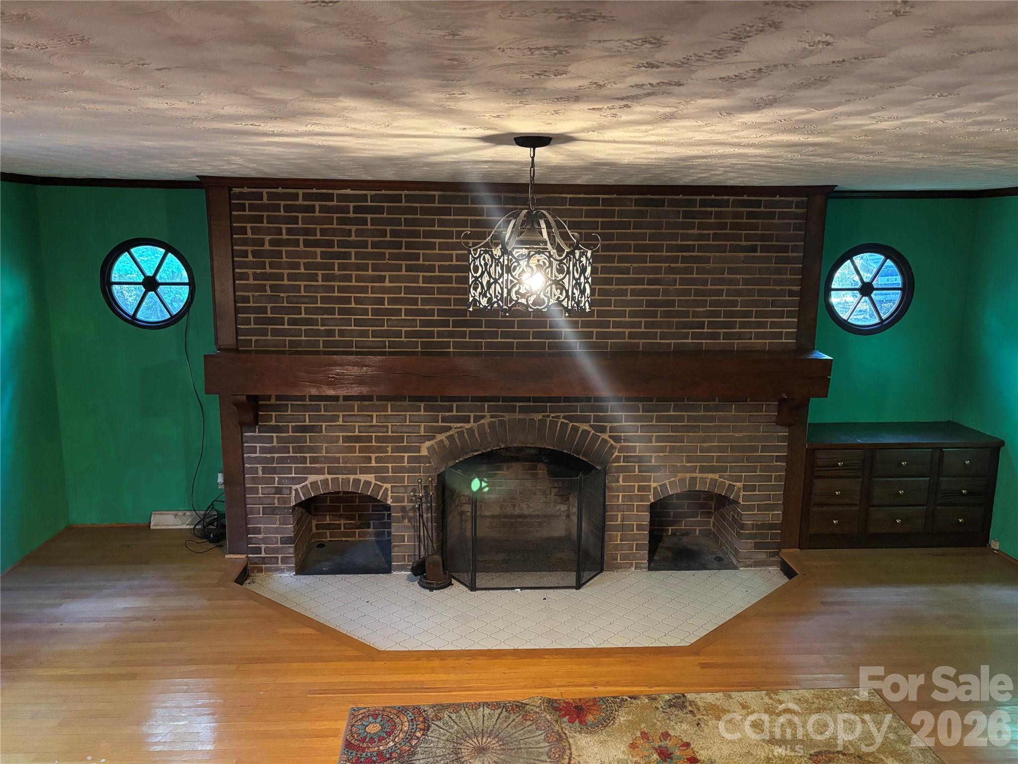Large living room fireplace with built-in cabinet. - 5923 Stack Road, Monroe