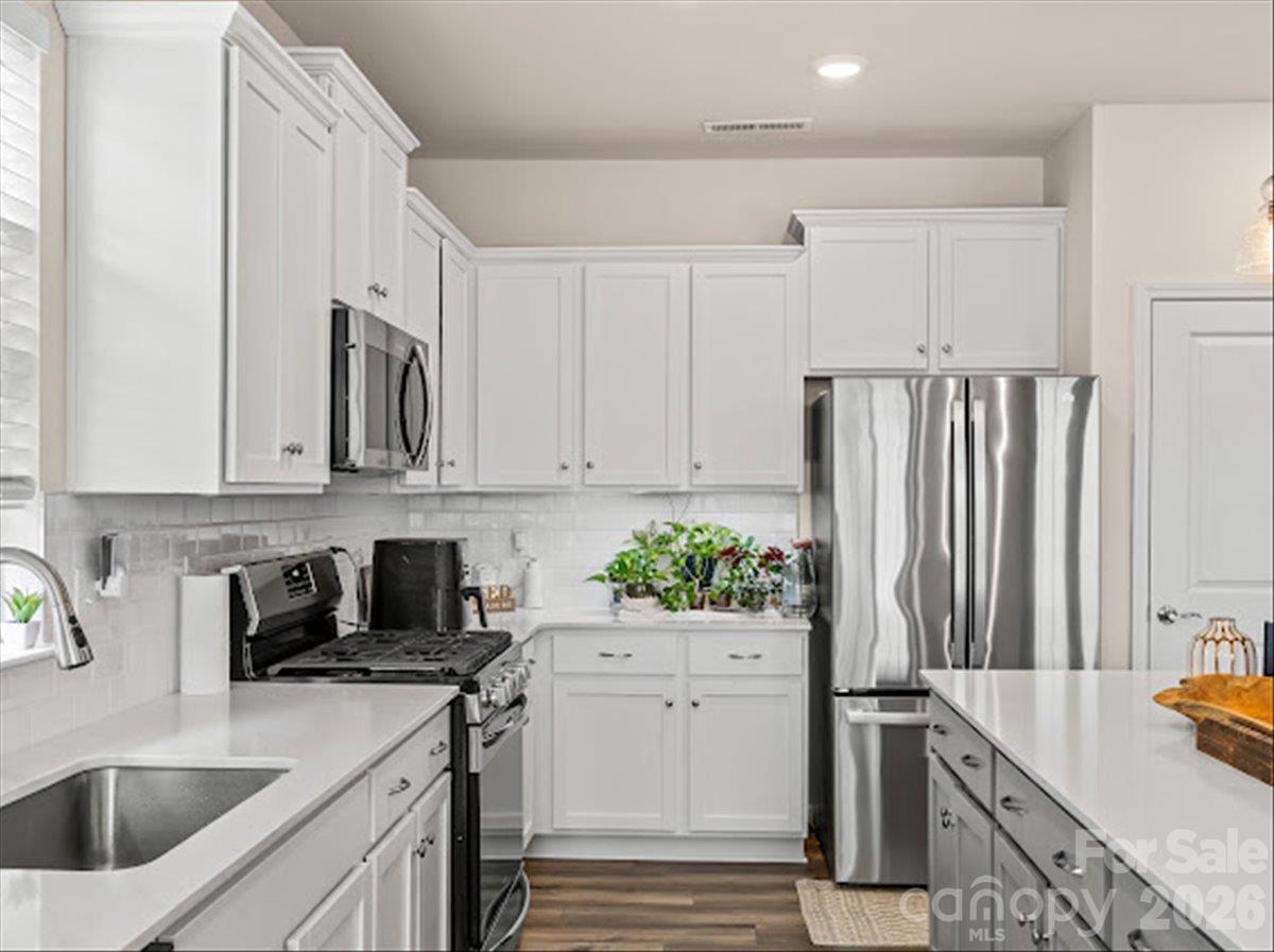 A chef's dream kitchen offering gorgeous countertops, ample storage space, and seamless flooring. - 155 White Apple Way, Statesville