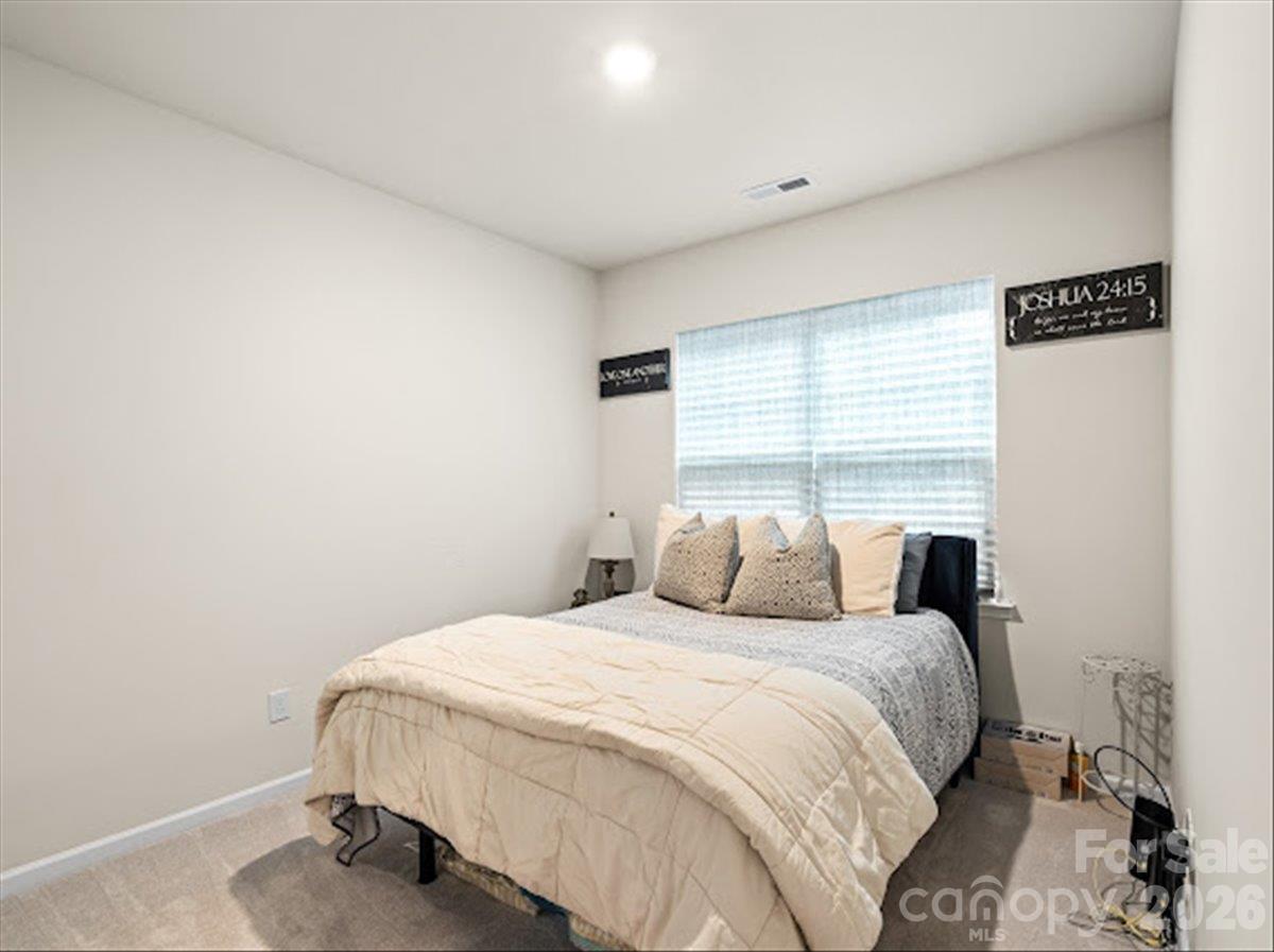 Comfortable and bright bedroom featuring a ceiling fan and a large window for plenty of natural light. - 155 White Apple Way, Statesville