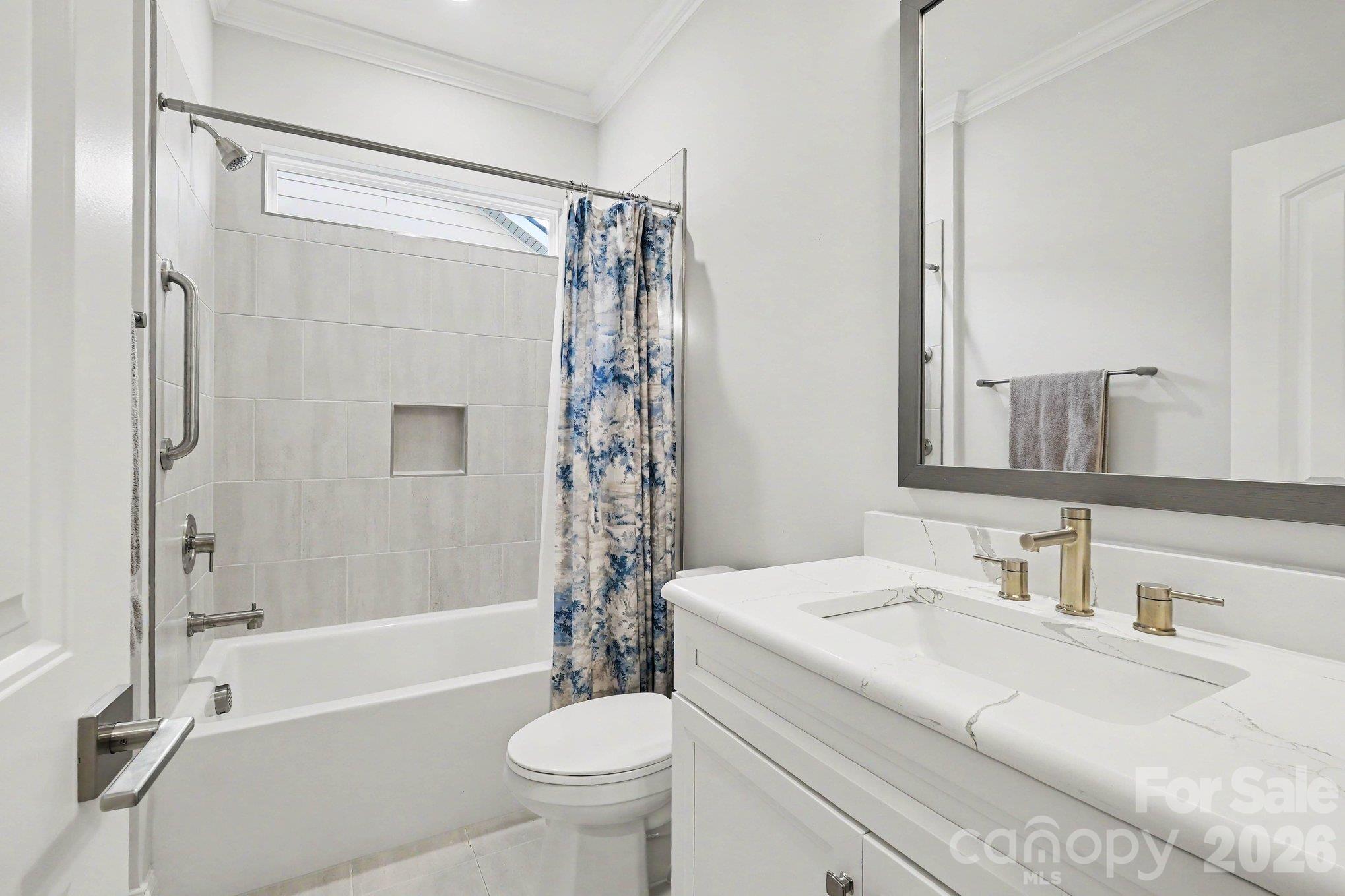 Main floor bathroom with built-ins and tiled  tub surround - 5605 Caneel Lane, Denver