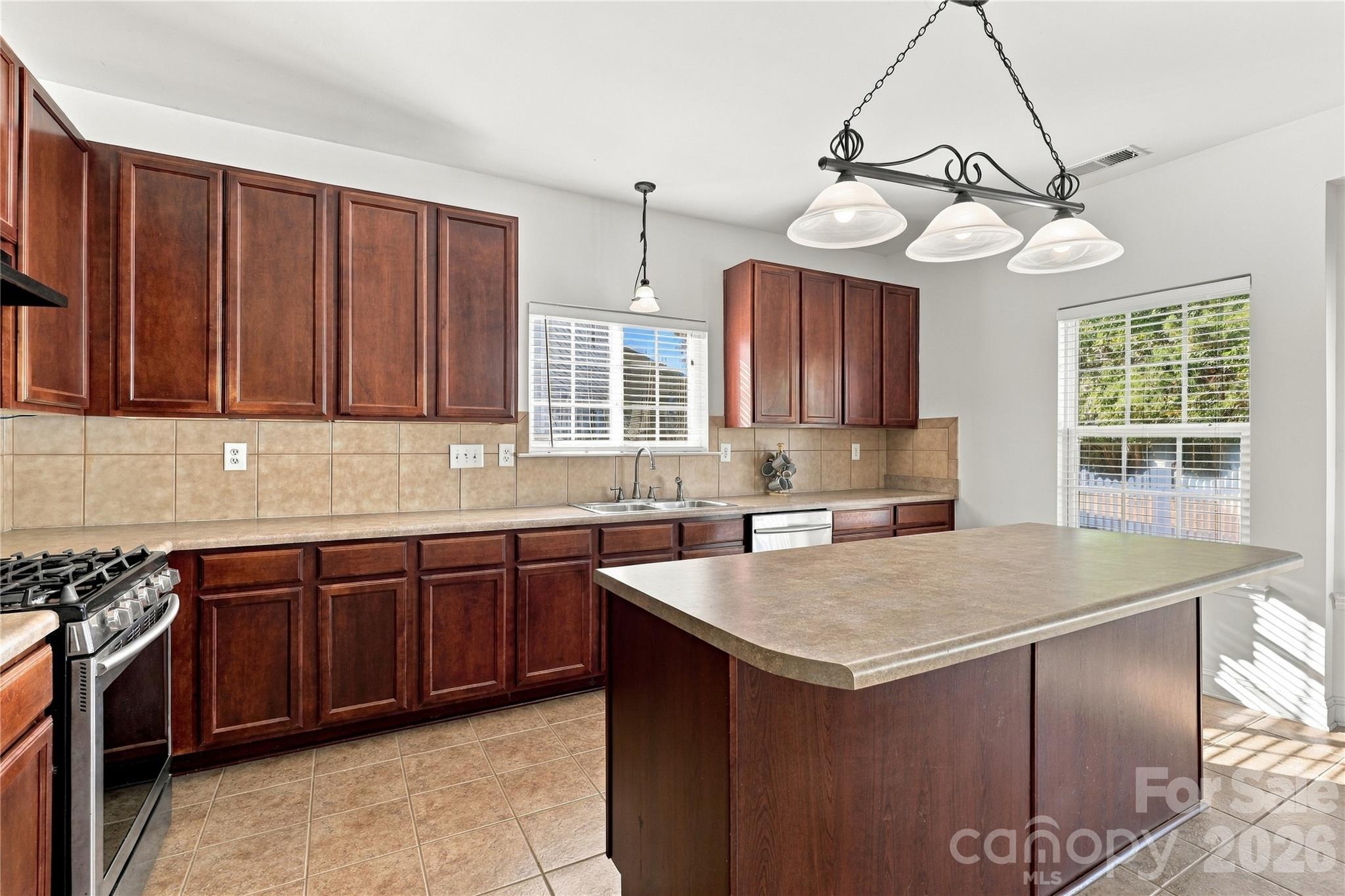 Rich cabinetry, a tile backsplash, and a large island give you plenty of room to cook and gather. - 327 Annaberg Lane, Monroe