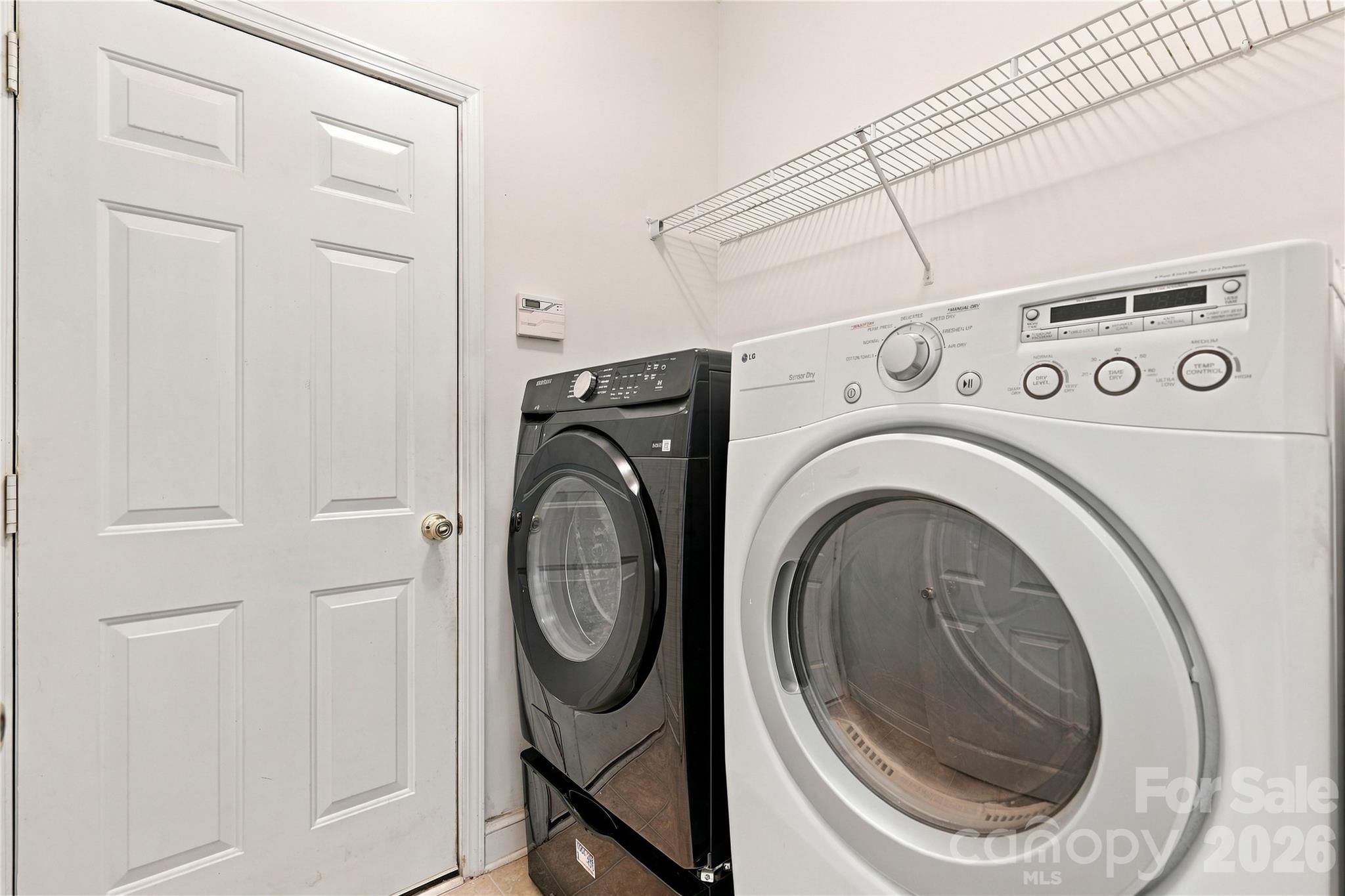 The laundry room has shelving and is located just off the garage for easy everyday chores. - 327 Annaberg Lane, Monroe