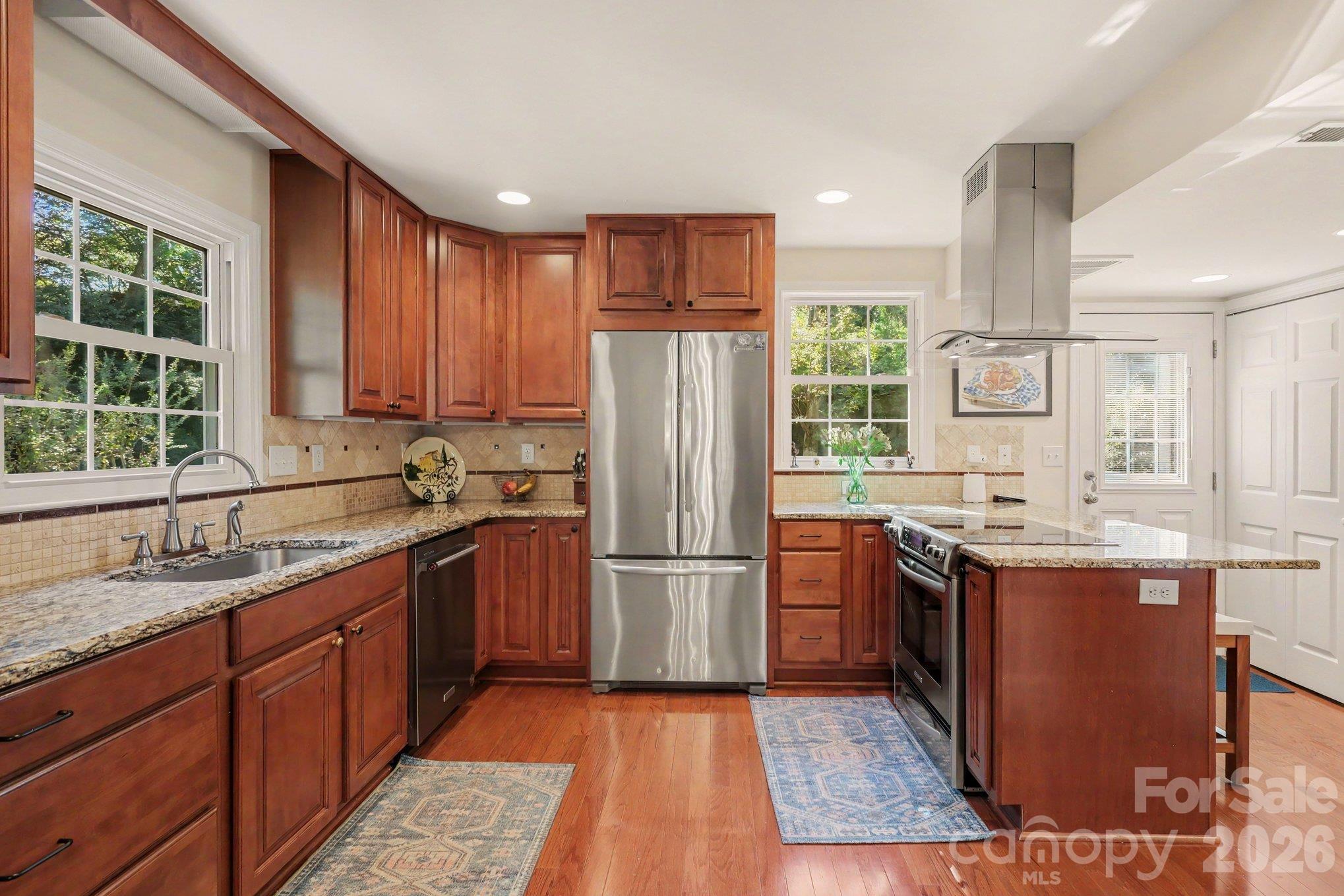 Open to the dining room, the kitchen was updated in 2010 and has an efficient layout. Stainless steel appliances and suspended hood vent. - 640 Heather Lane, Charlotte