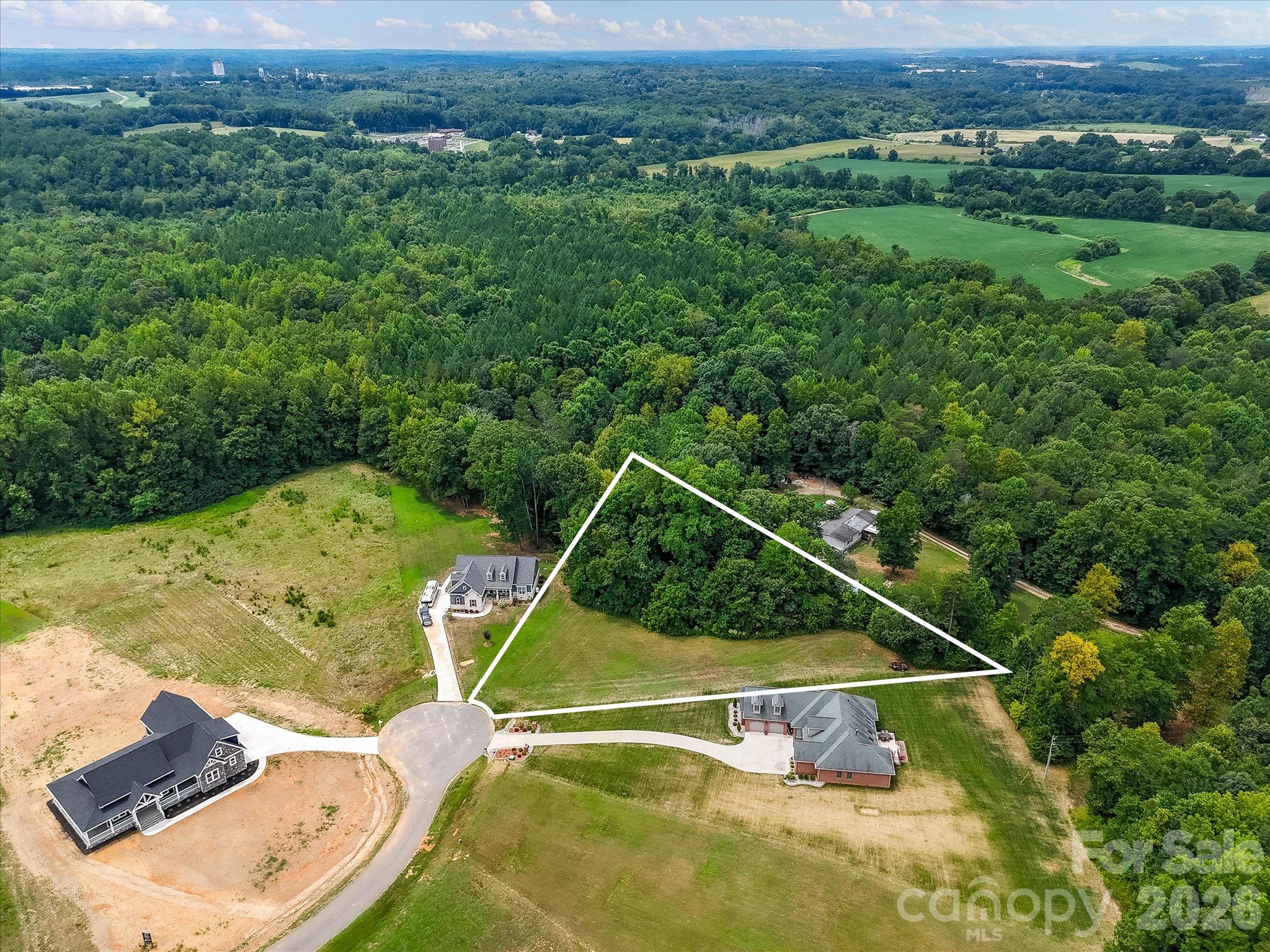 Aerial view highlighting the beautifully situated cul-de-sac homesite, outlined to showcase its expansive open lawn, mature trees, and peaceful wooded backdrop offering exceptional privacy and natural beauty. - Lot 15 Peacehaven Place, Statesville