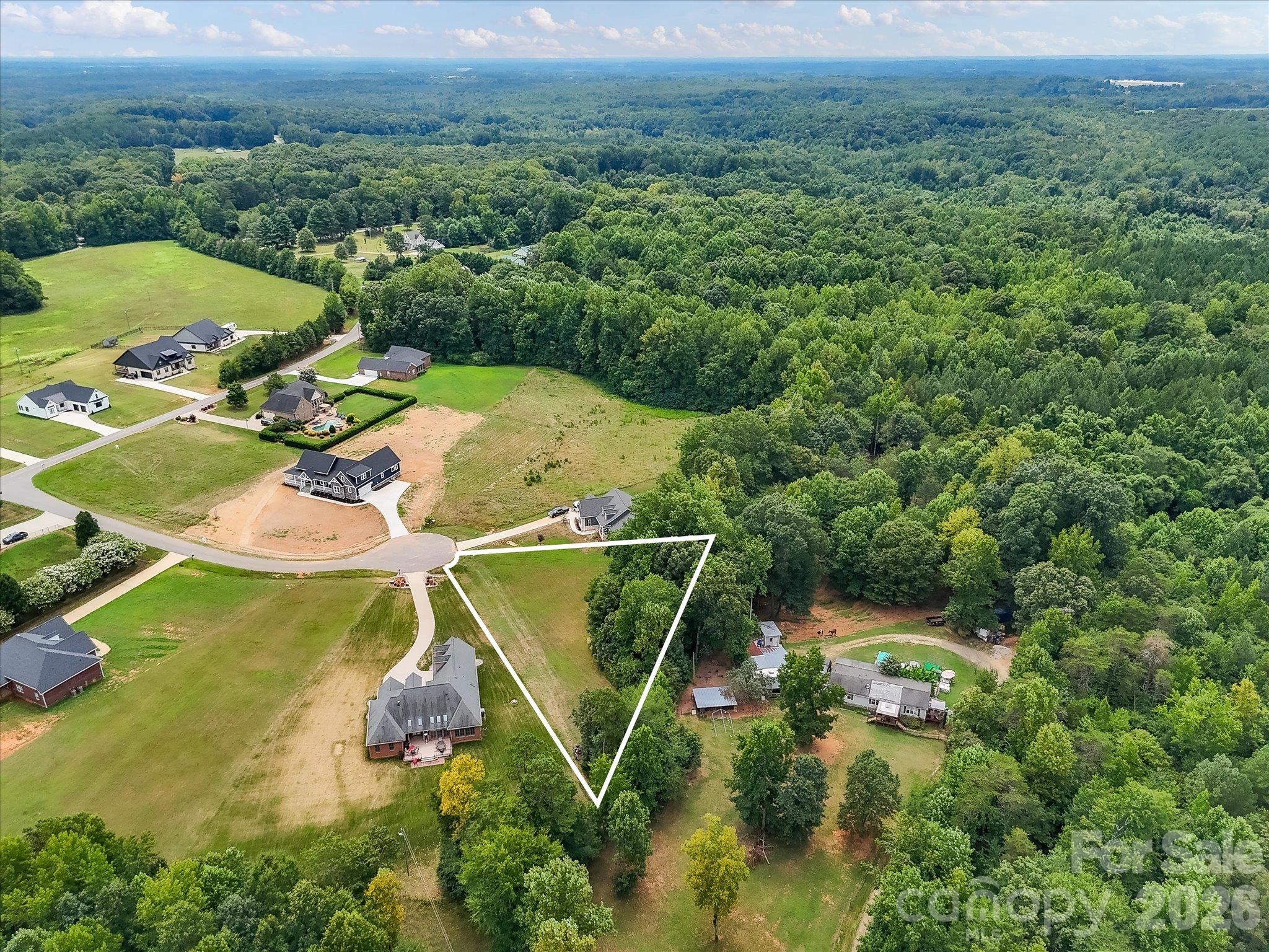 Expansive aerial view showcasing a peaceful cul-de-sac community with spacious homesites, beautiful custom homes, and lush wooded surroundings offering privacy and picturesque countryside scenery. - Lot 15 Peacehaven Place, Statesville