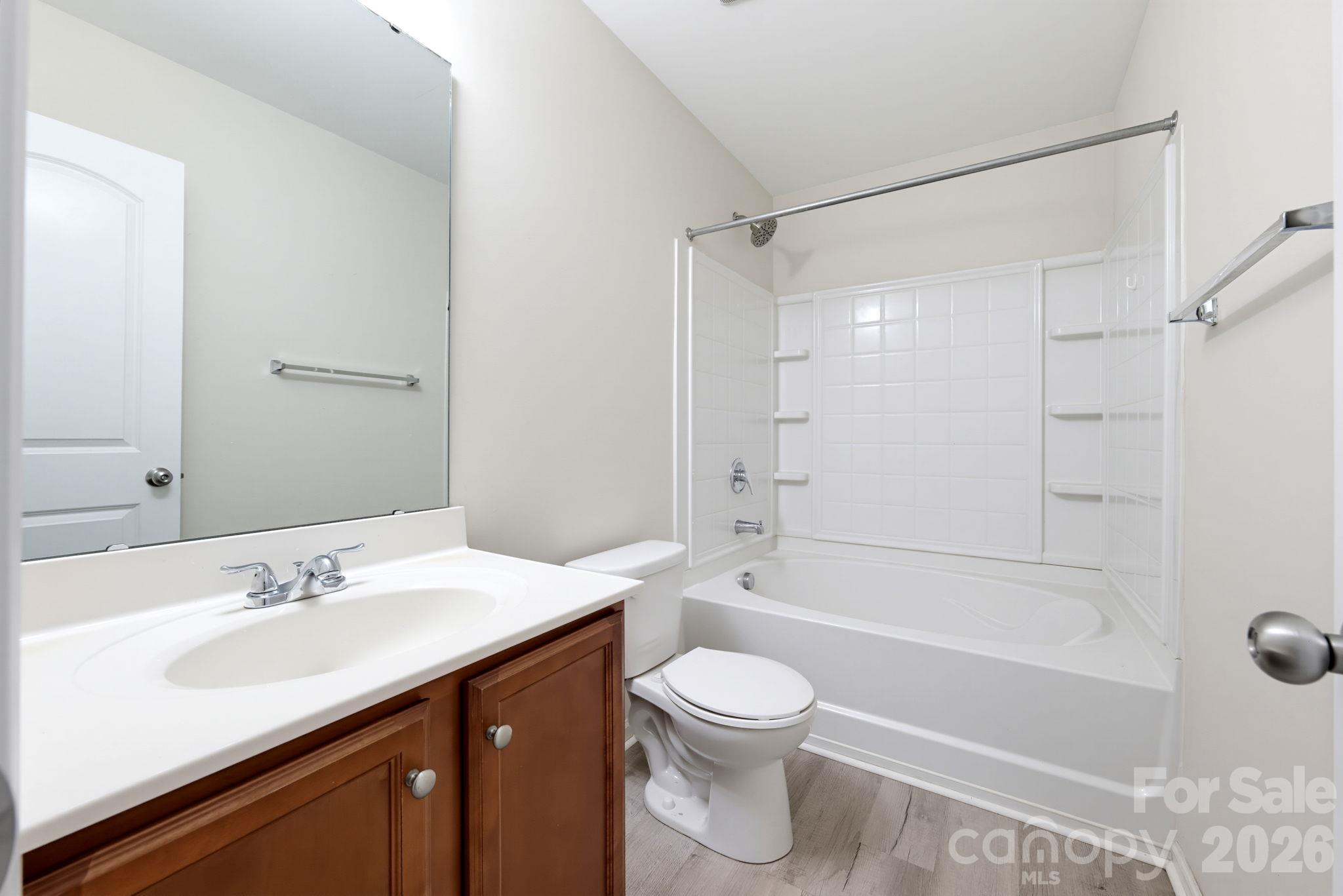 Full bathroom featuring a vanity, bathtub and shower combination, and neutral finishes. - 5718 Natick Drive, Charlotte