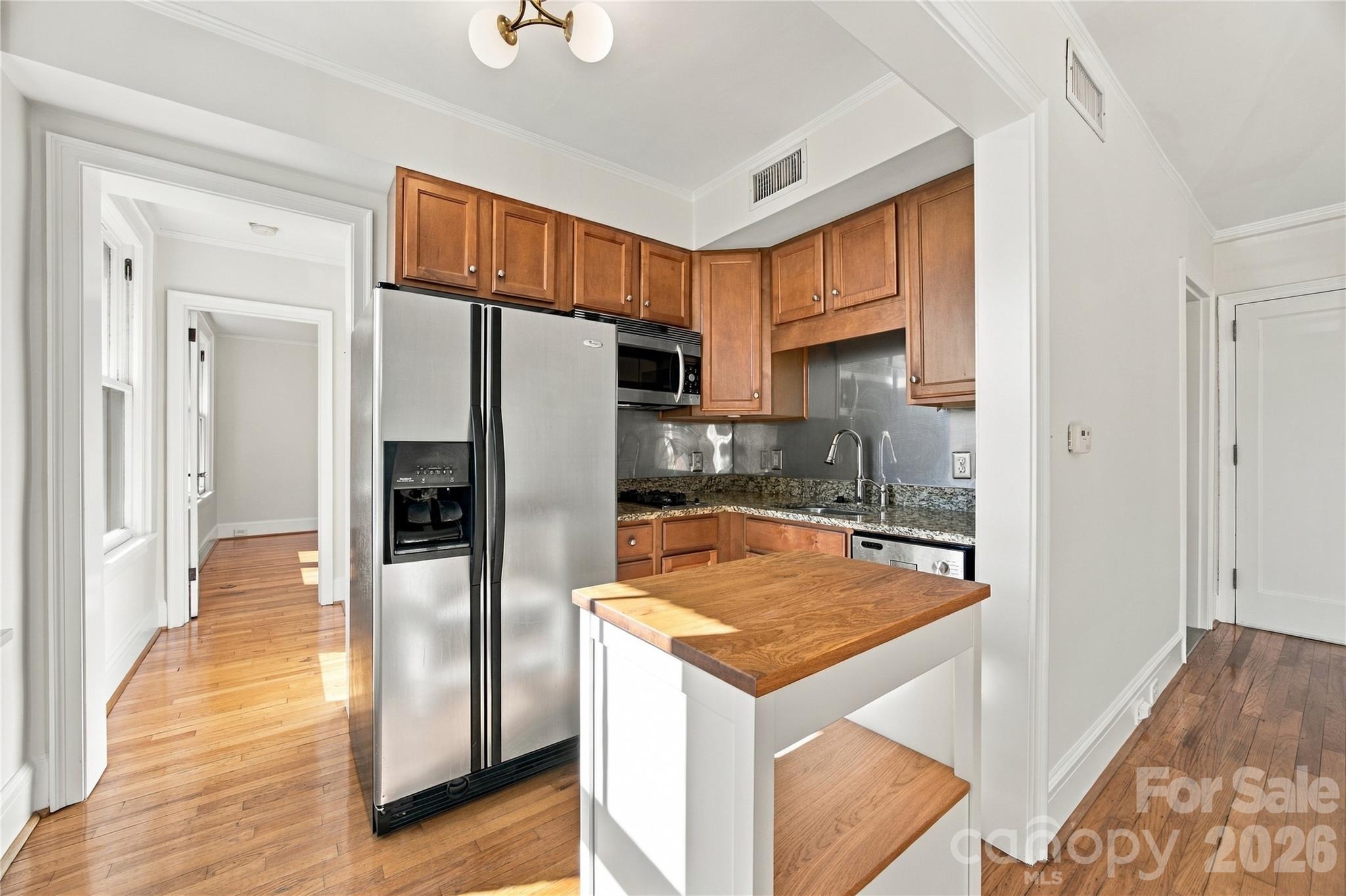 Lovely windows bring sunshine and character to everyday cooking with a peek into the bedroom - 712 Louise Avenue, Charlotte