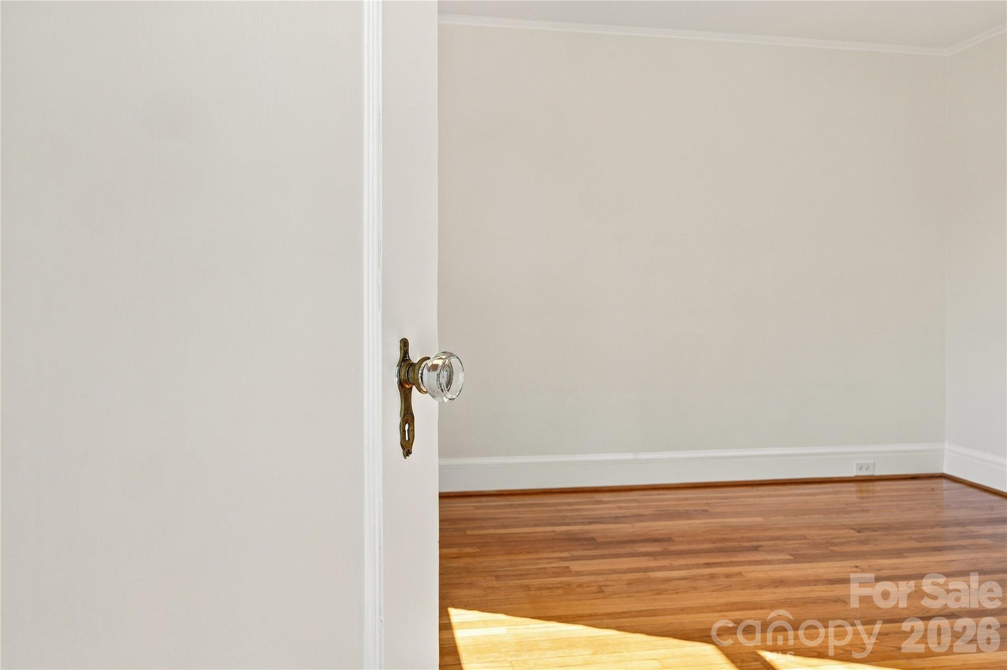 A sunlit doorway offers an inviting glimpse of the bedroom beyond. - 712 Louise Avenue, Charlotte