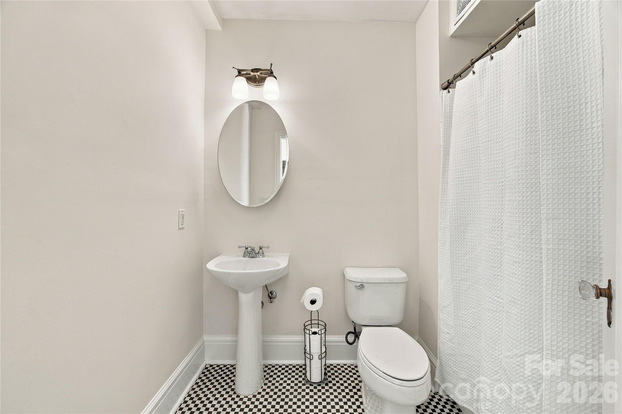 Full Bathroom - Vintage charm, everyday comfort - original checkerboard tile and a thoughtful layout make this private en suite a classic. - 712 Louise Avenue, Charlotte