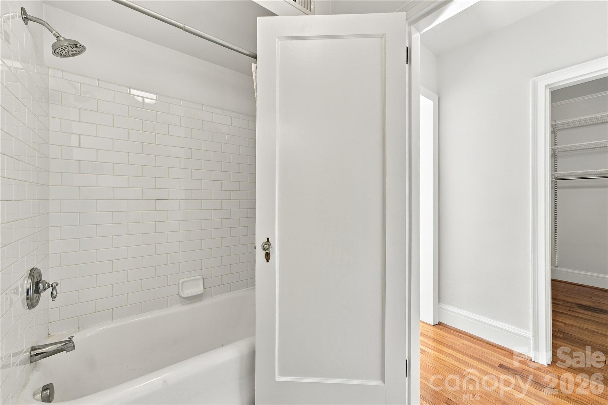 Full Bath - Classic white tile frames the tub and shower for a fresh, timeless look. - 712 Louise Avenue, Charlotte