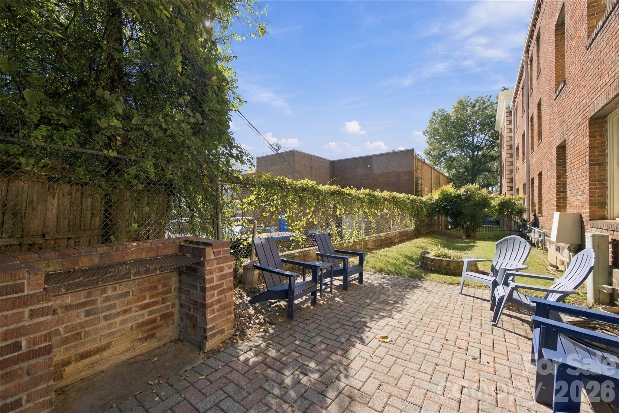 Fresh air for you, room to roam for your pup - this fenced shared courtyard doubles as a dog run, with seating for catching up with neighbors. - 712 Louise Avenue, Charlotte
