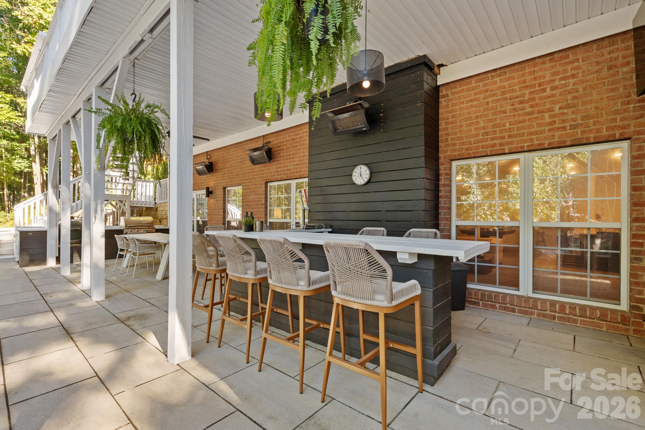 Outdoor bar area with kegerator, dining area to the left as well as bbq space - 148 Sunrise Circle, Mooresville