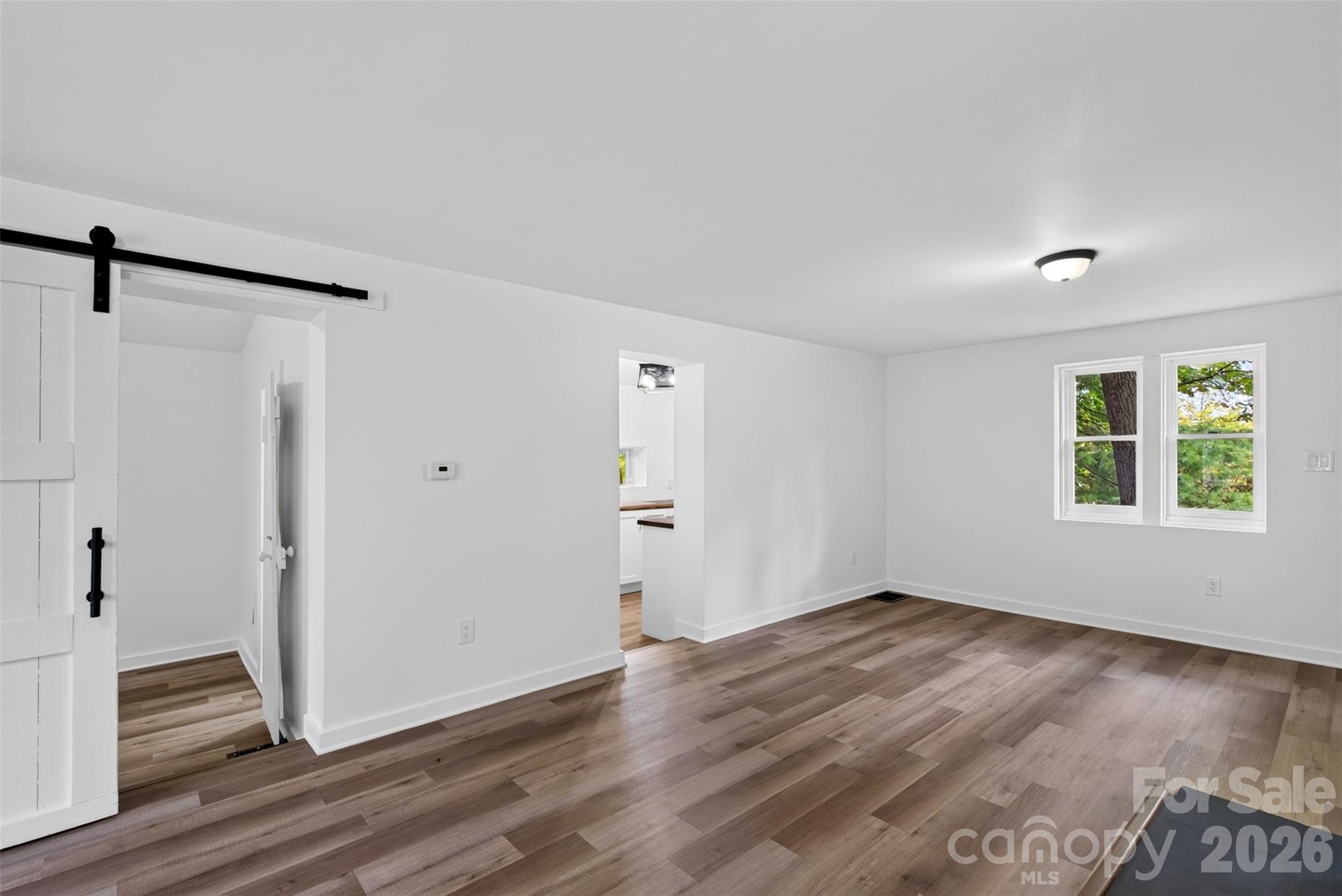 Living room looking to the kitchen and bedroom on main. - 64 Pine Cone Drive, Asheville