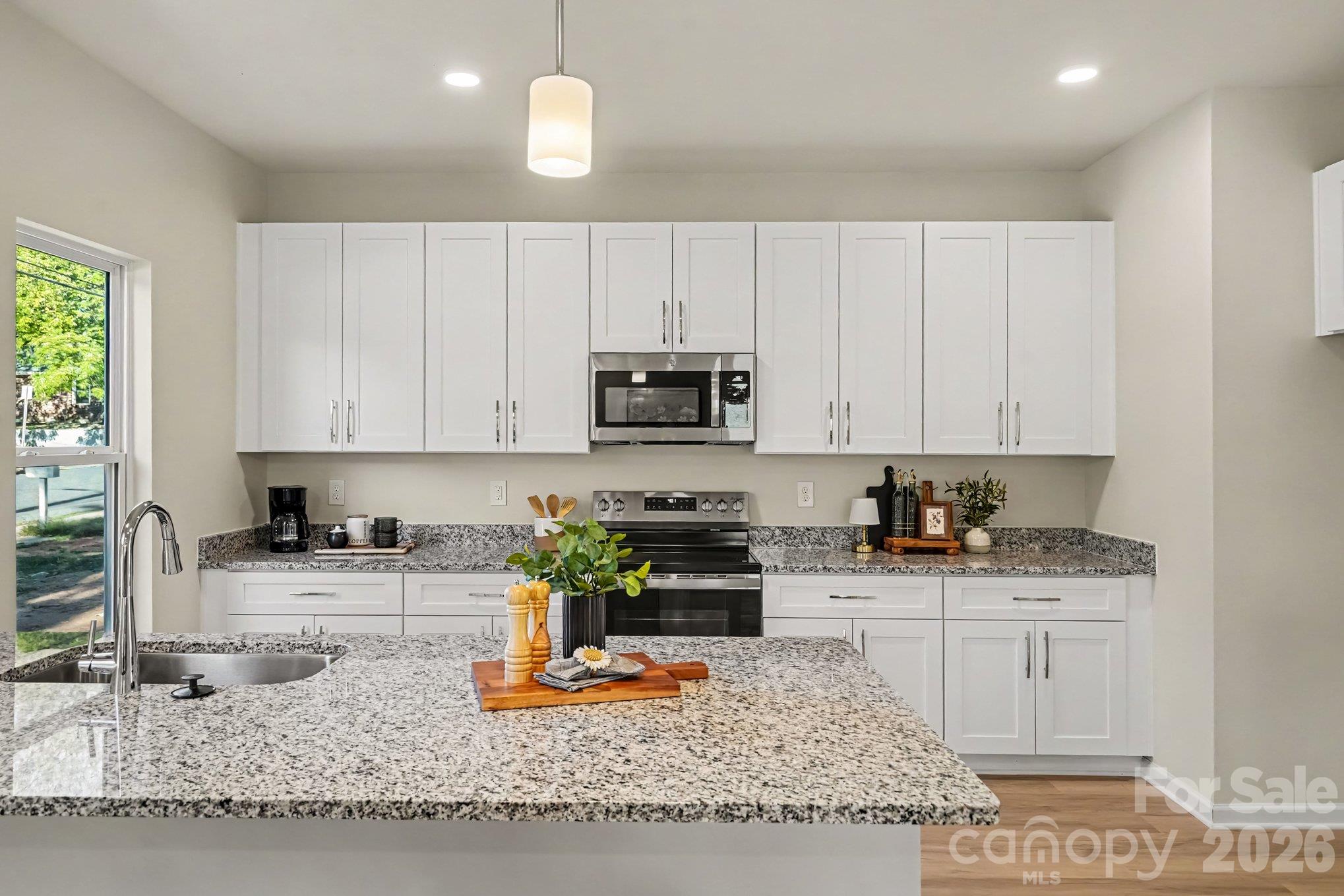 Kitchen has electric range, microwave, disposal and dishwasher. The sink is a farm style stainless steel type. Beautiful granite countertops. - 121 Buffalo Avenue NW, Concord
