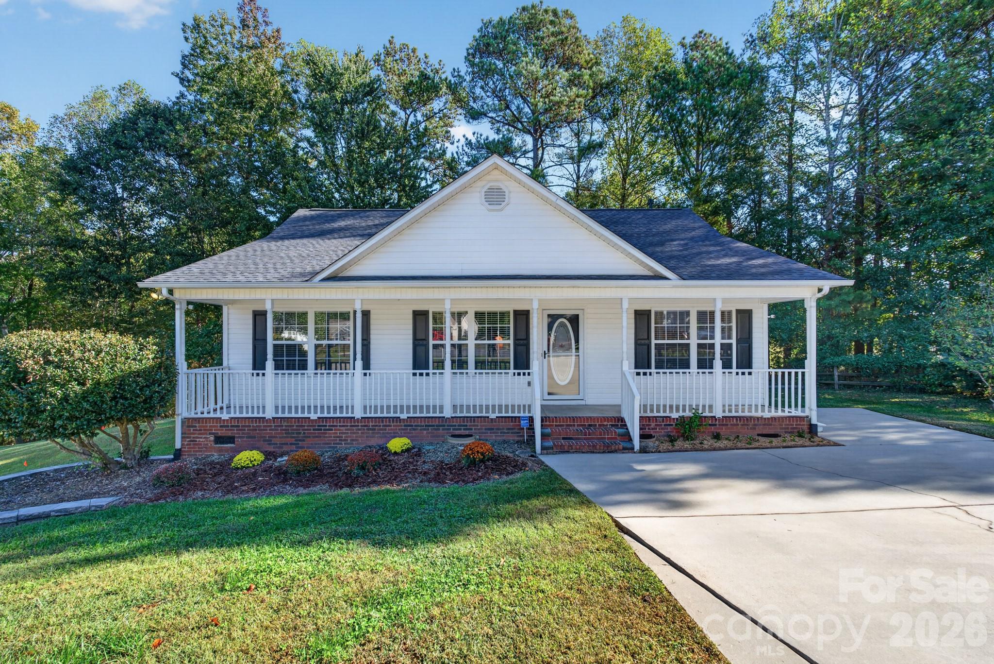 Charming Southern-style ranch featuring classic white siding, timeless architectural details, and an inviting front yard with fantastic curb appeal. - 702 Painted Lady Court, Rock Hill