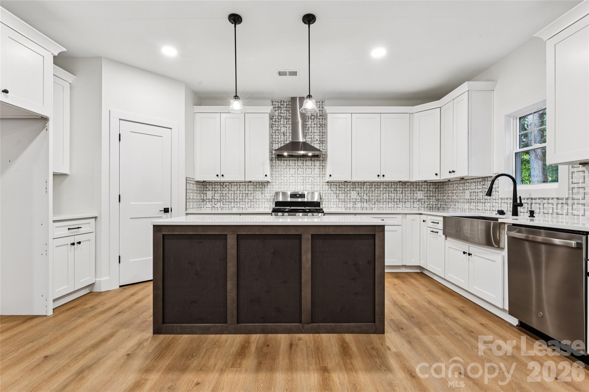 Kitchen with large island, stainless steel appliances, farm sink and backsplash - 11924 Crabapple Lane, Huntersville