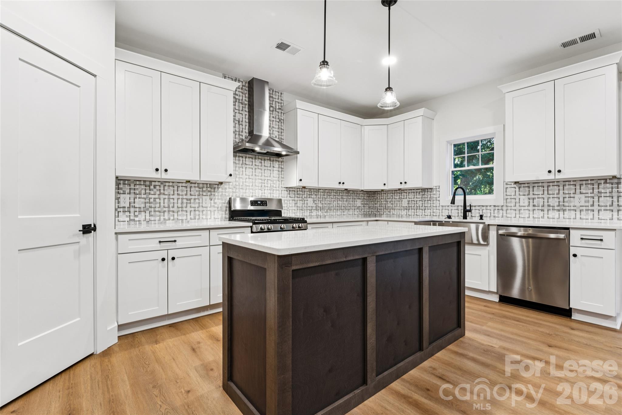 Kitchen with large island, stainless steel appliances, farm sink and backsplash - 11924 Crabapple Lane, Huntersville