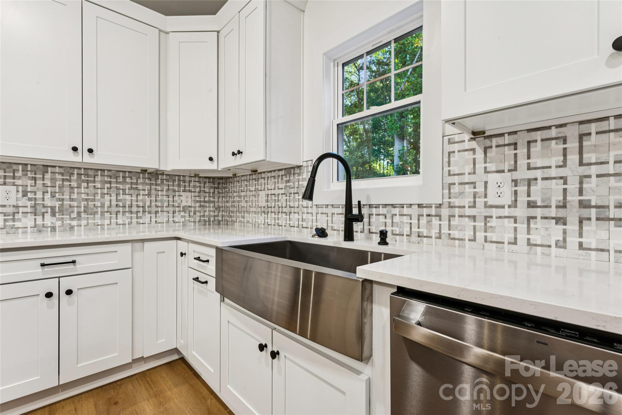 Kitchen with large island, stainless steel appliances, farm sink and backsplash - 11924 Crabapple Lane, Huntersville