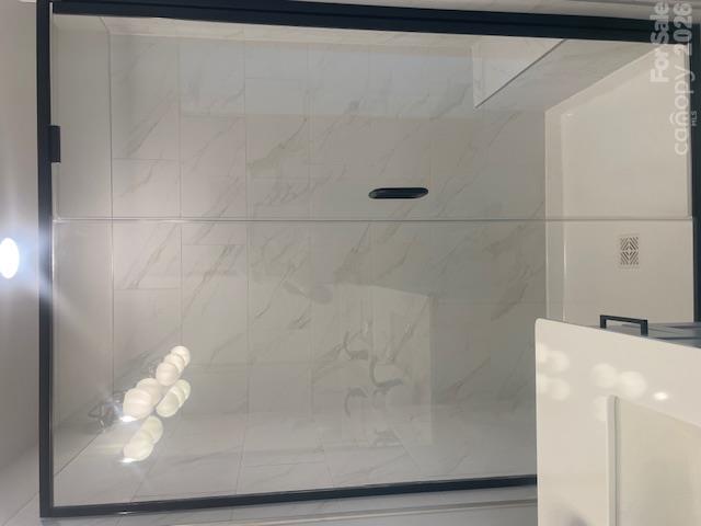 Owners bathroom features large shower with bench 12x24 ceramic tile - 257 Alluvium Lane, Waxhaw
