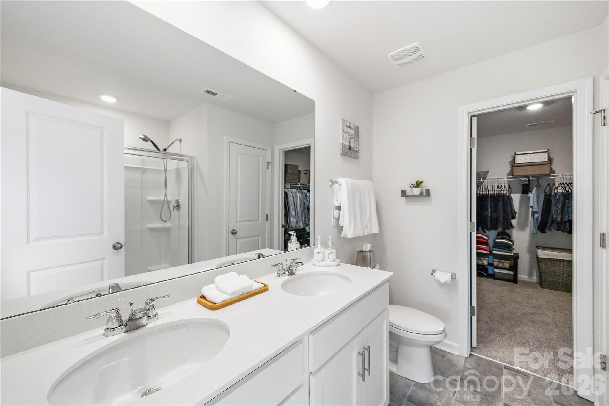 Upper level- primary bedroom ensuite bathroom with dual vanities. - 9022 Poquoson Drive, Gastonia