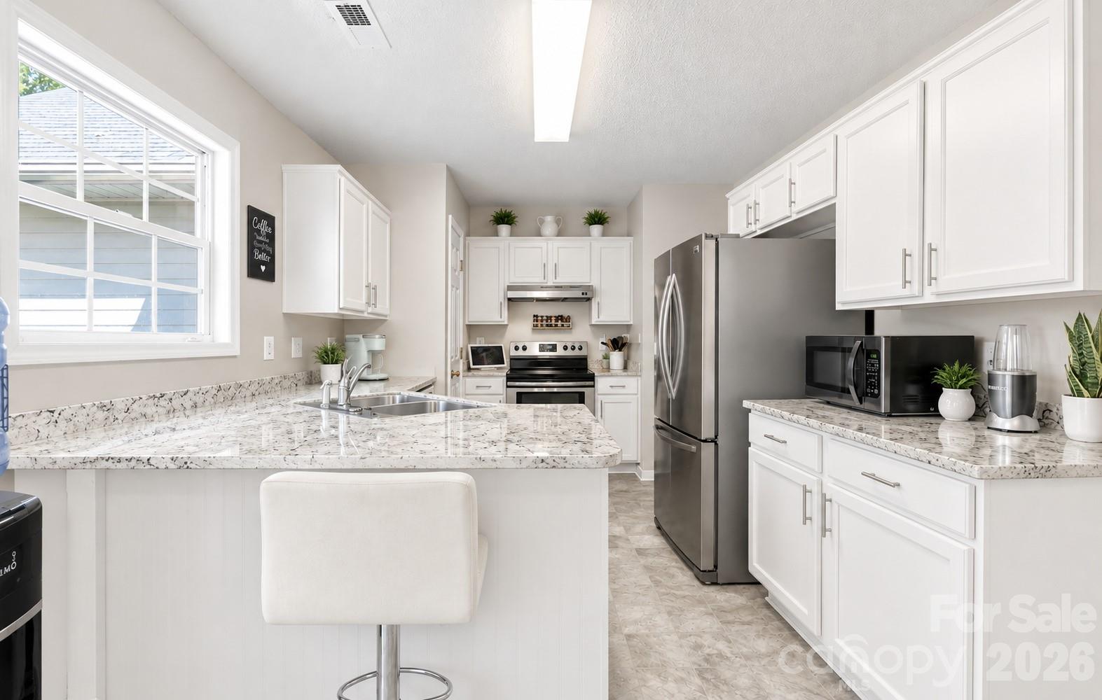 AI used to show If Cabinets were painted white and granite counters added. - 2116 Gambrel Way, Monroe