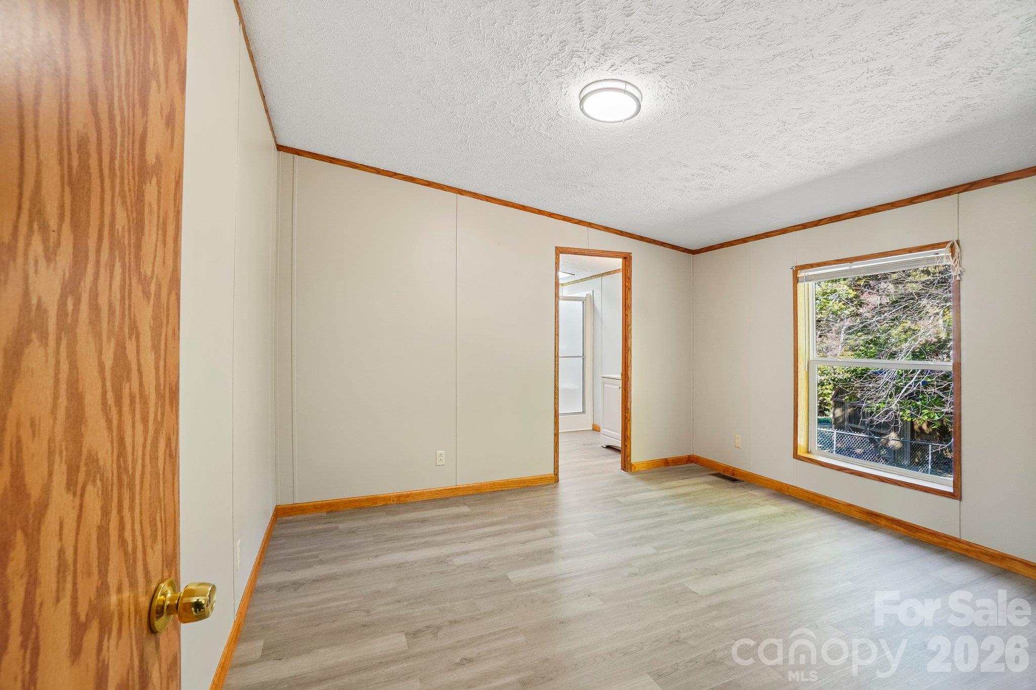 In the family room, to the left of the fireplace, enter the primary bedroom. - 202 Banyan Road, Candler