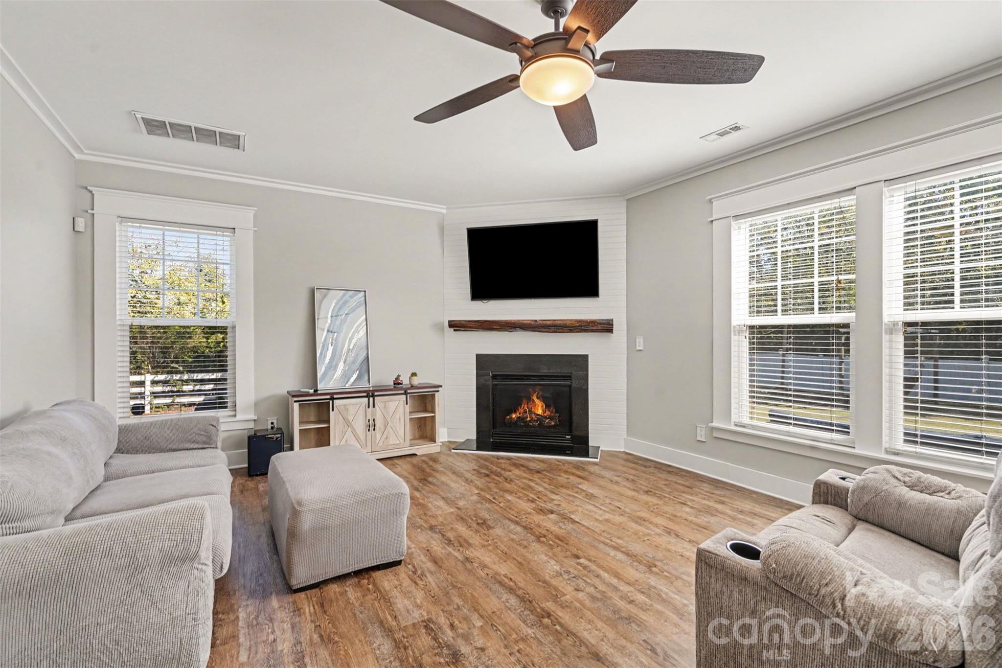 This beautiful Great Room is open to the Breakfast Area and Kitchen. Gas Logs, custom made mantle and wall treatment. Fresh, neutral paint just completed. Attention to detail...the windows have beautiful trim added for an upscale look. - 3585 Leighton Drive SW, Concord