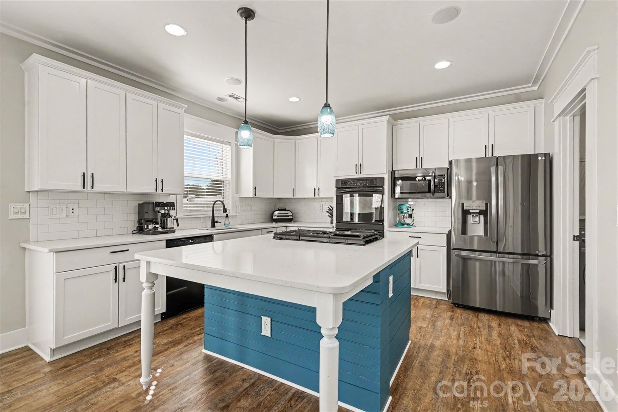 Love the look of this beautiful island, perfect for entertaining or a place to eat and gather. Crisp, white cabinetry and black stainless and black appliances for a streamlined look. Walk in Pantry. - 3585 Leighton Drive SW, Concord